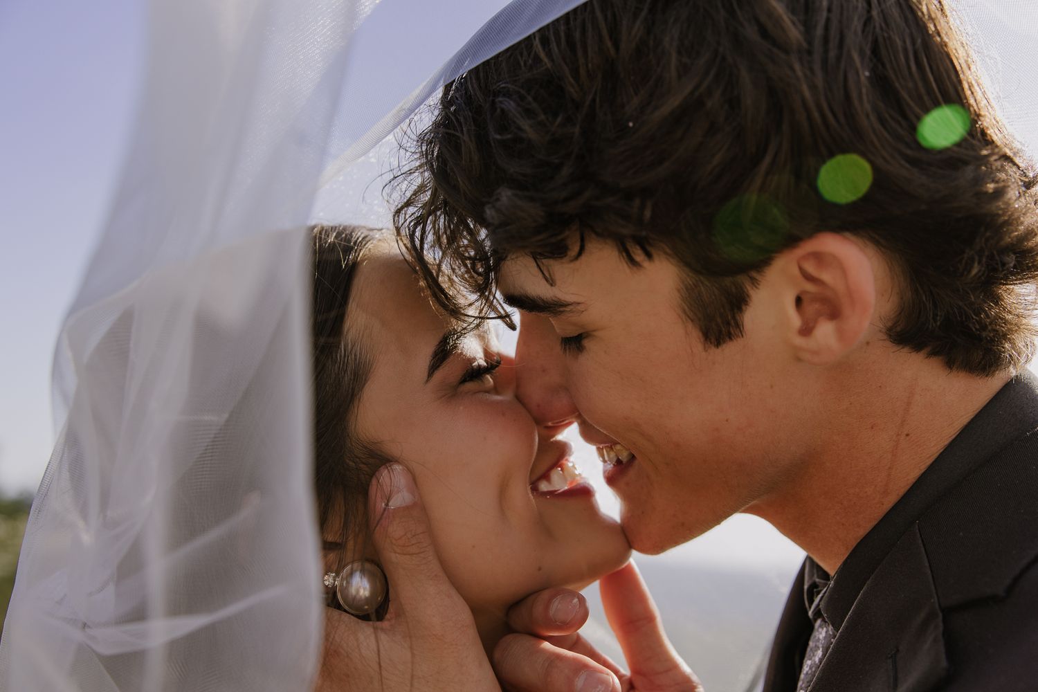 Romantic close-up wedding portraits showing tender moments between newlyweds against a blurred background.