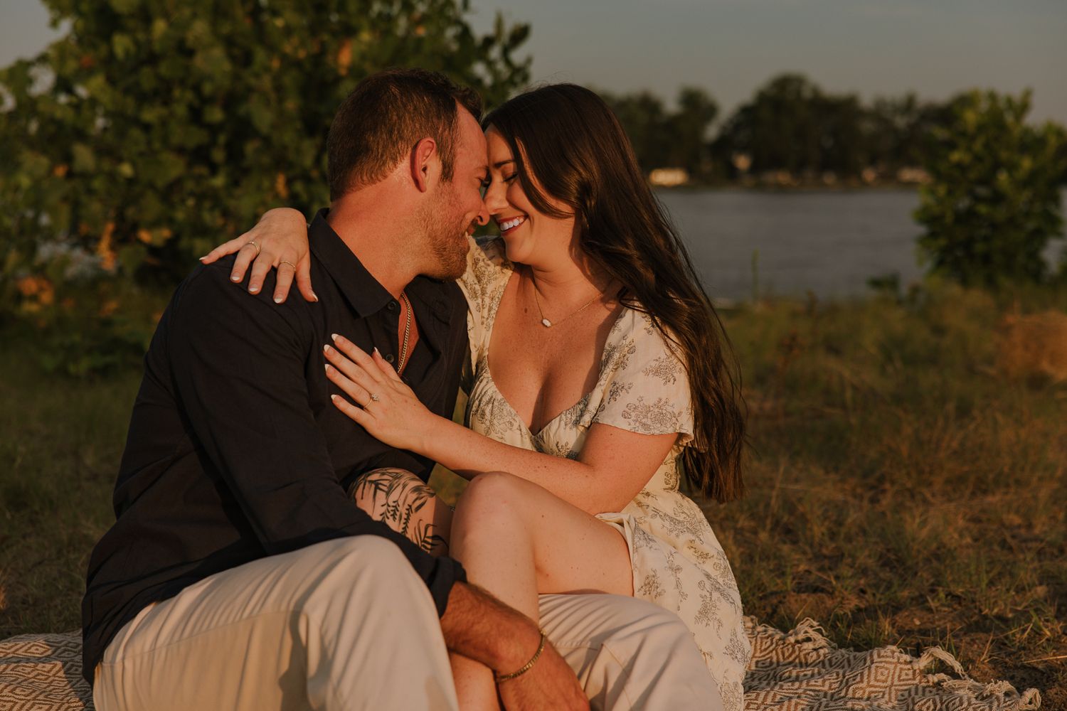 Tender moment shared between couple during sunset lakeside photoshoot.