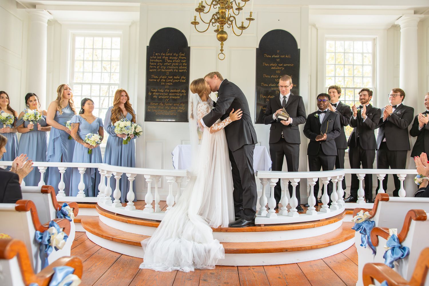 Panoramic view of an elegant church wedding ceremony with white balustrades and guests in attendance.