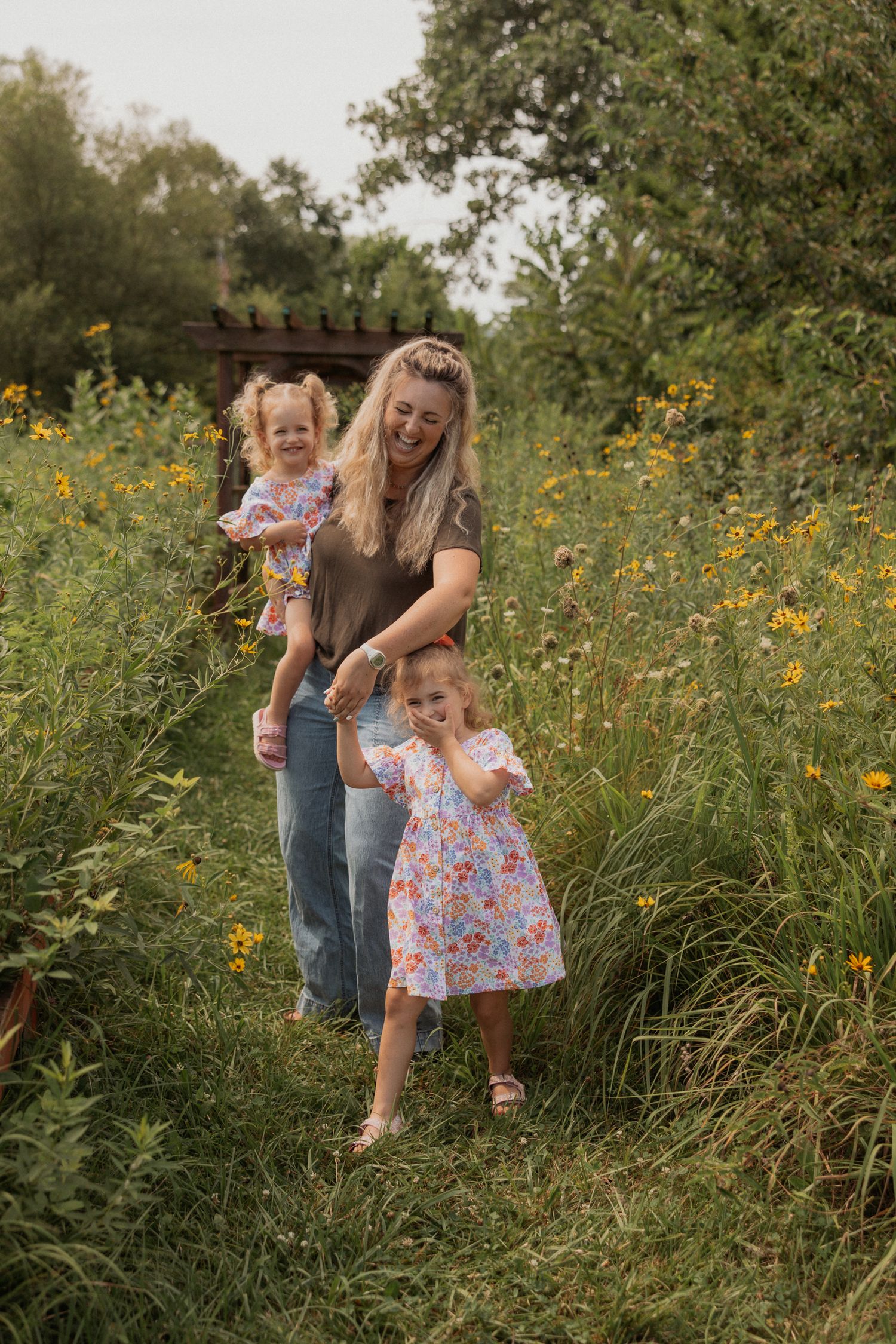 Joyful moment captured in a summer meadow with yellow flowers and wooden pergola.