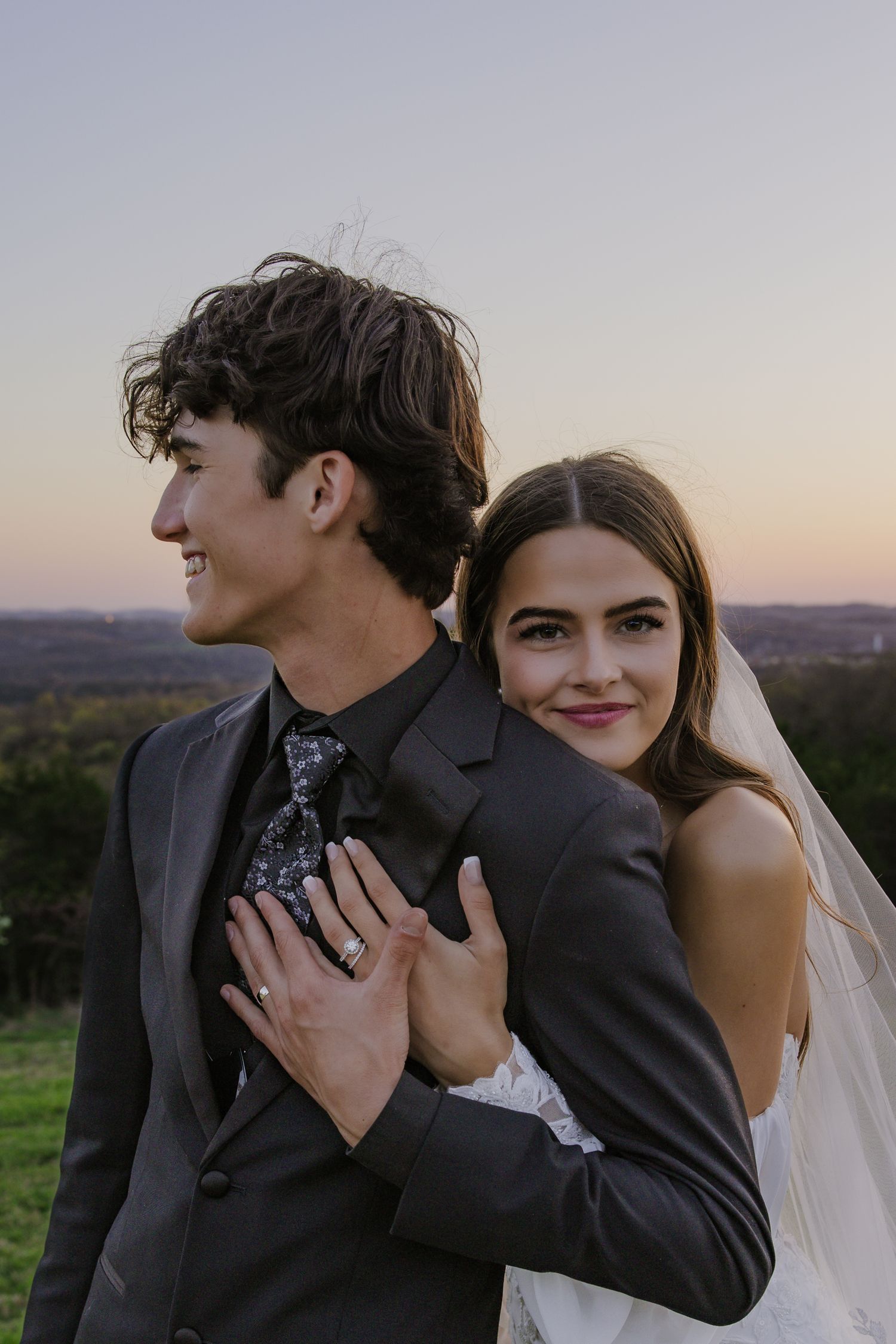 Intimate wedding couple portraits captured at sunset in an outdoor hilltop setting.