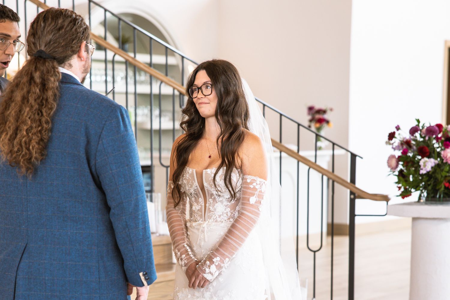 Elegant indoor wedding venue with wooden staircase and natural lighting.