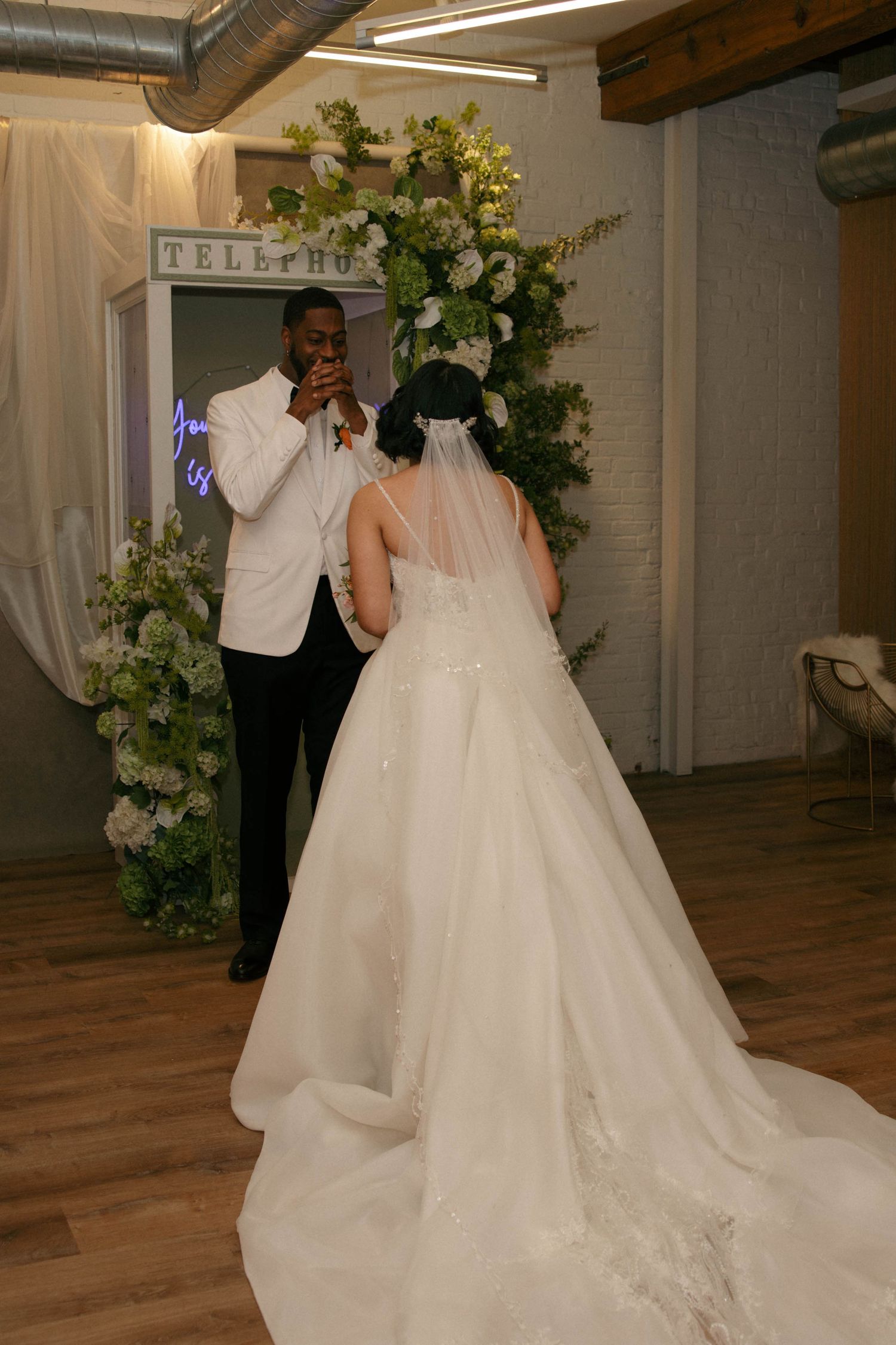 Elegant wedding reception venue decorated with white floral arrangements and wooden beam accents.