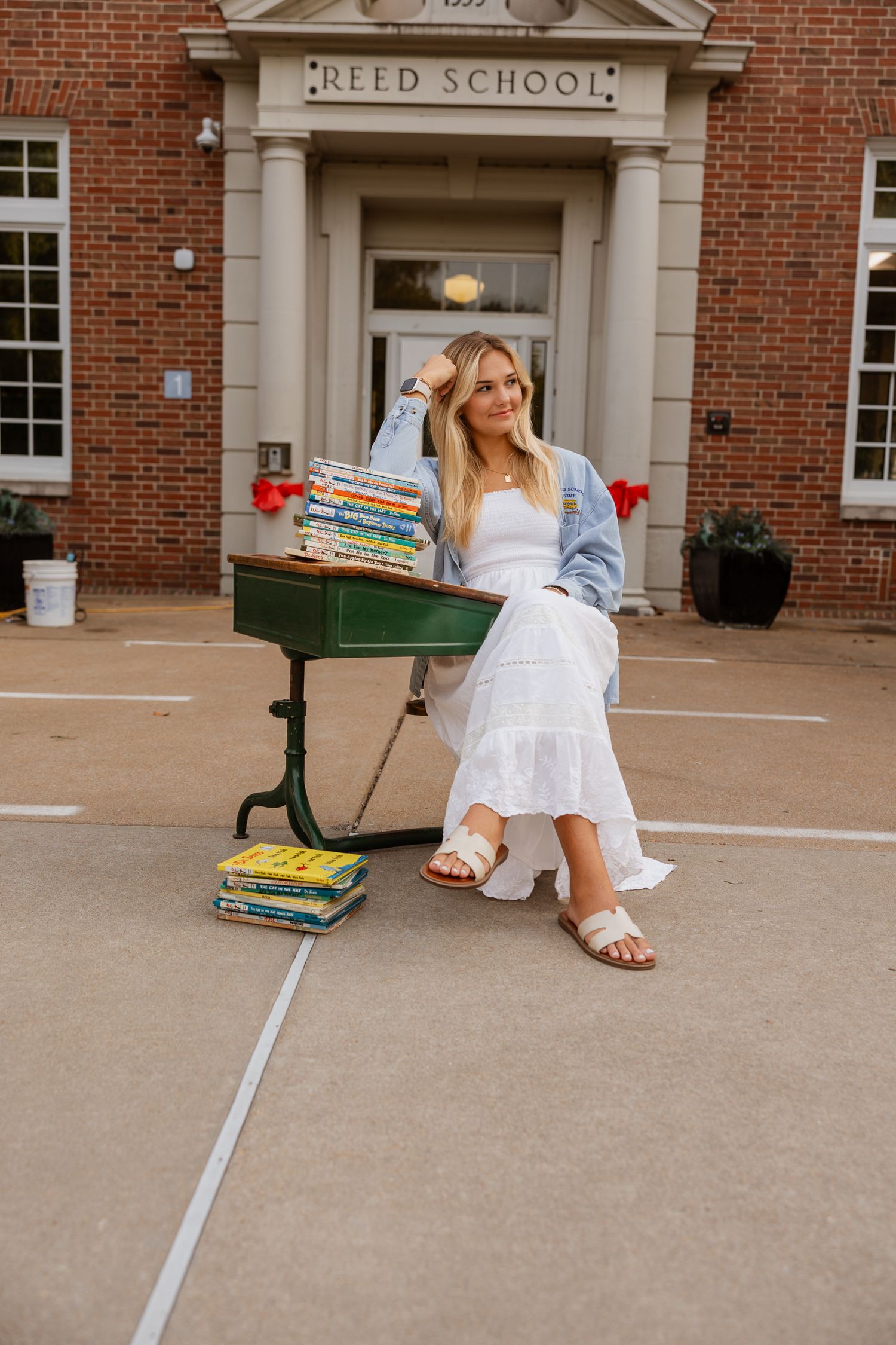A relaxed pose on school steps showcases Dr. Seuss books and summer fashion.