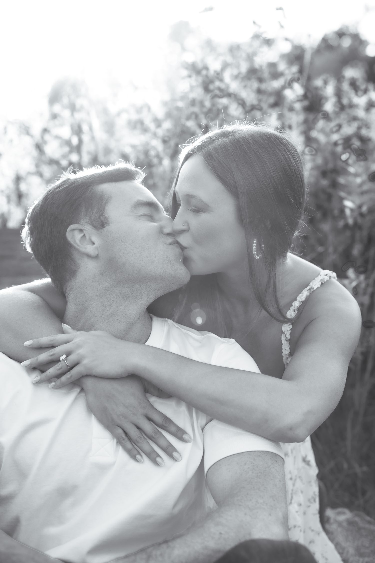 Black and white series of romantic kisses between couple in natural setting.