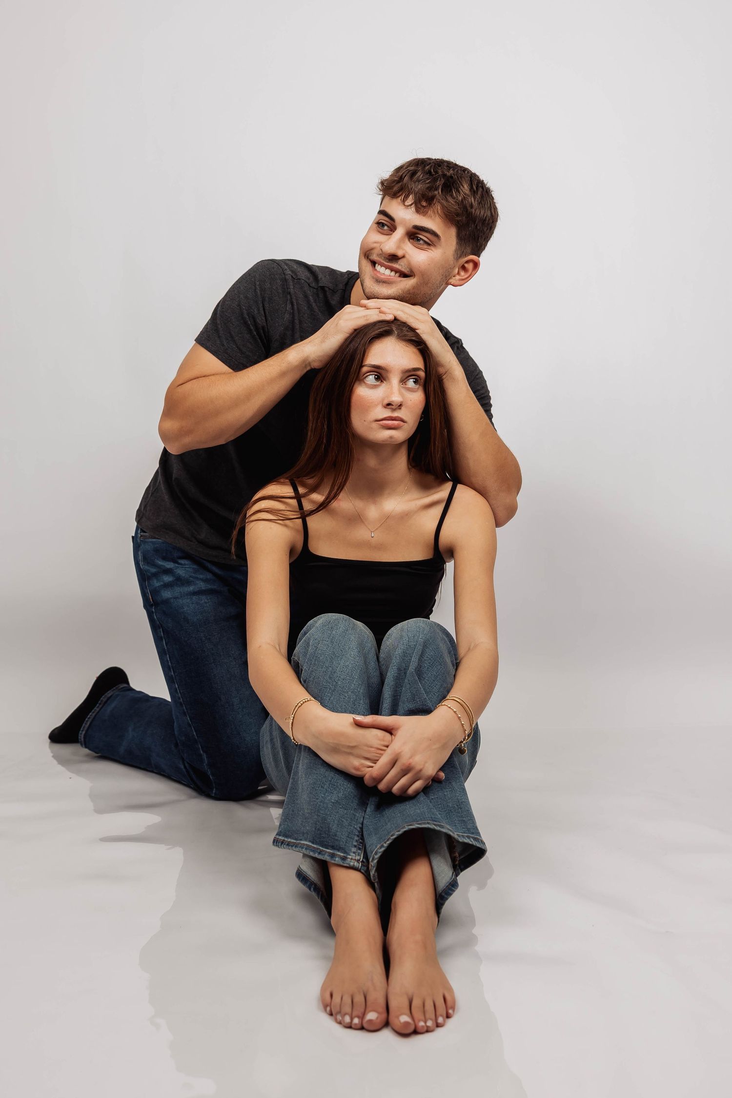 Intimate couple portrait session showing tender moments on studio floor.