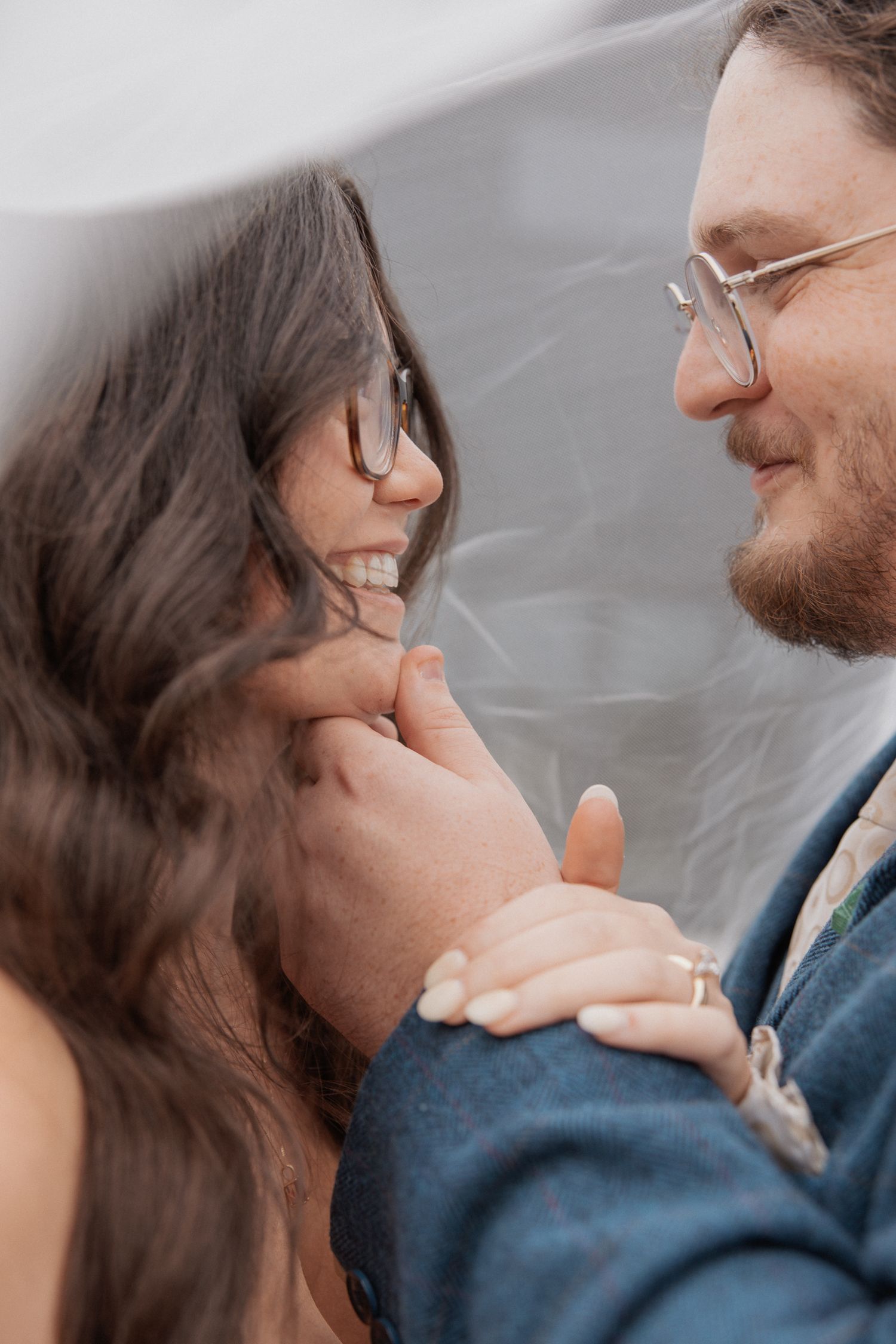 Intimate close-up of couple sharing tender moment against gray background.
