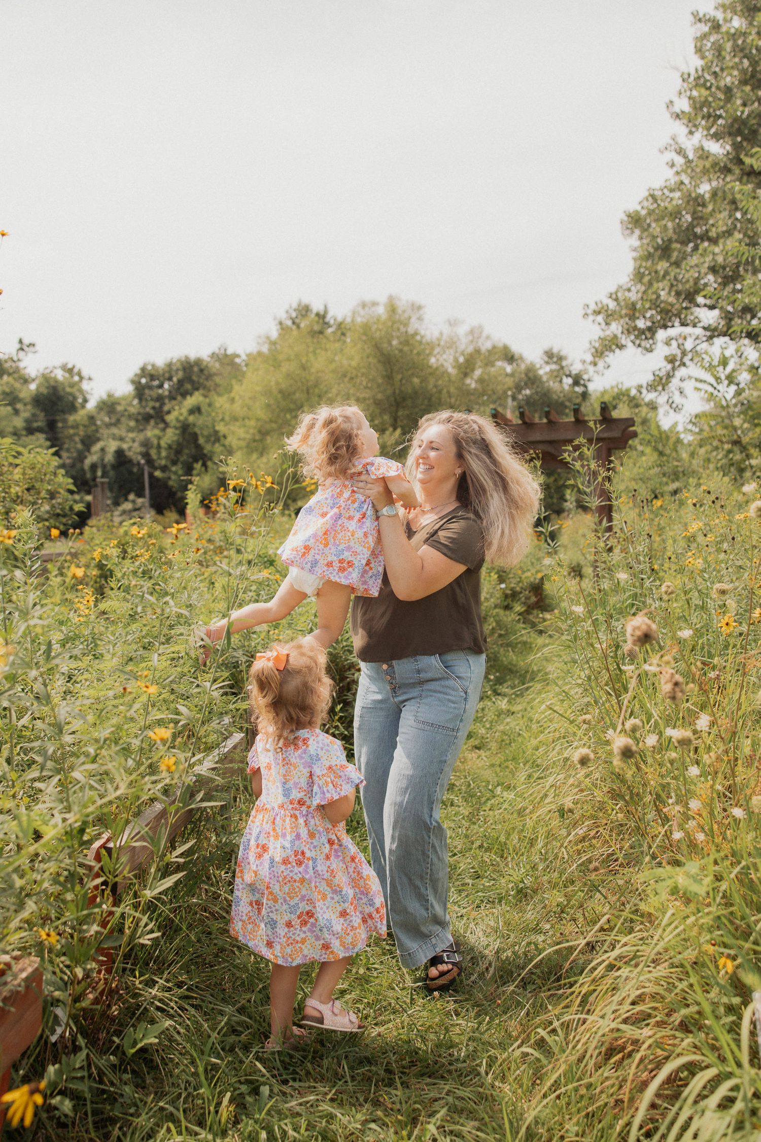 A joyful outdoor scene in a wildflower meadow with matching floral dresses and playful interactions.