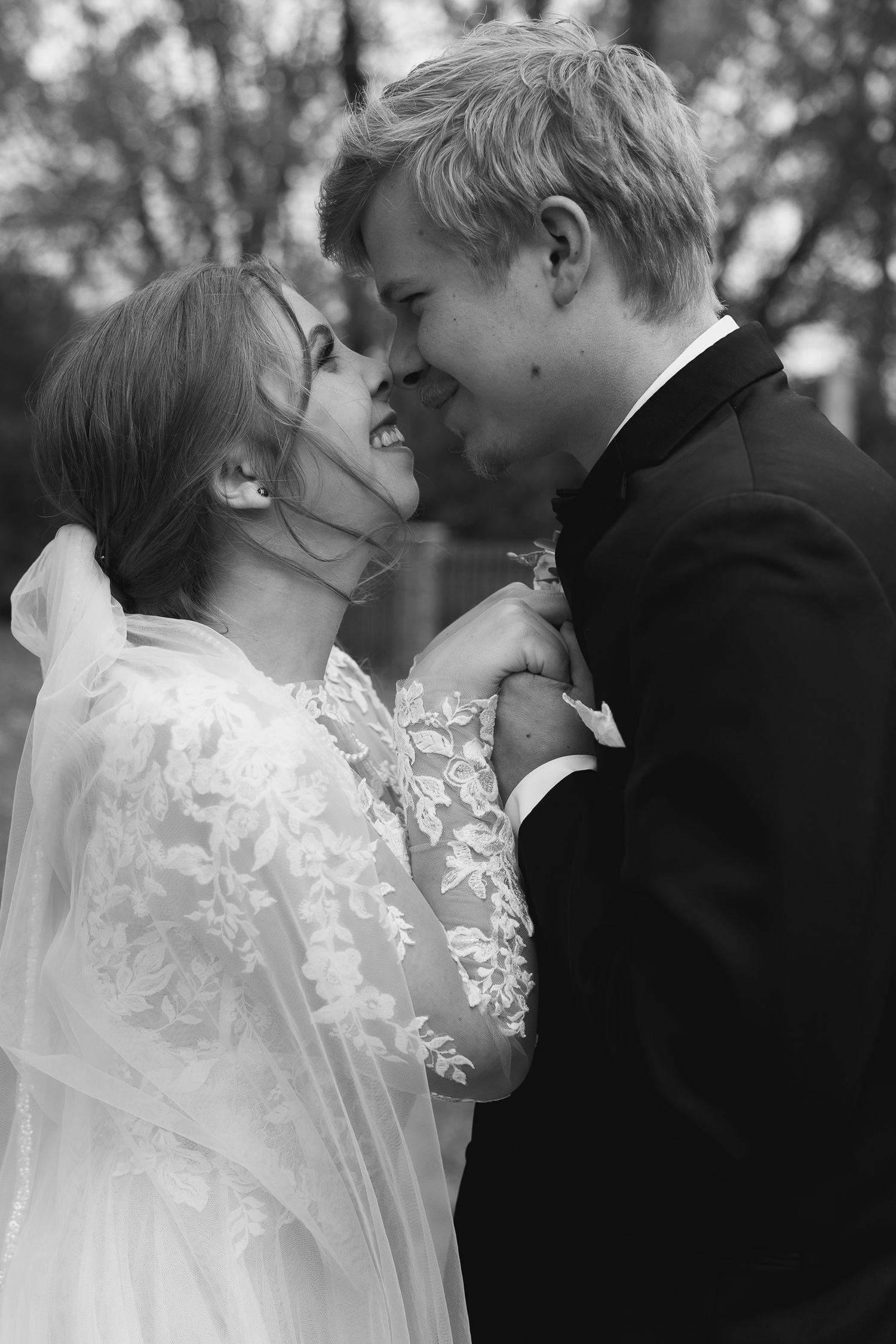 Intimate black and white wedding portraits captured outdoors with delicate lace details.