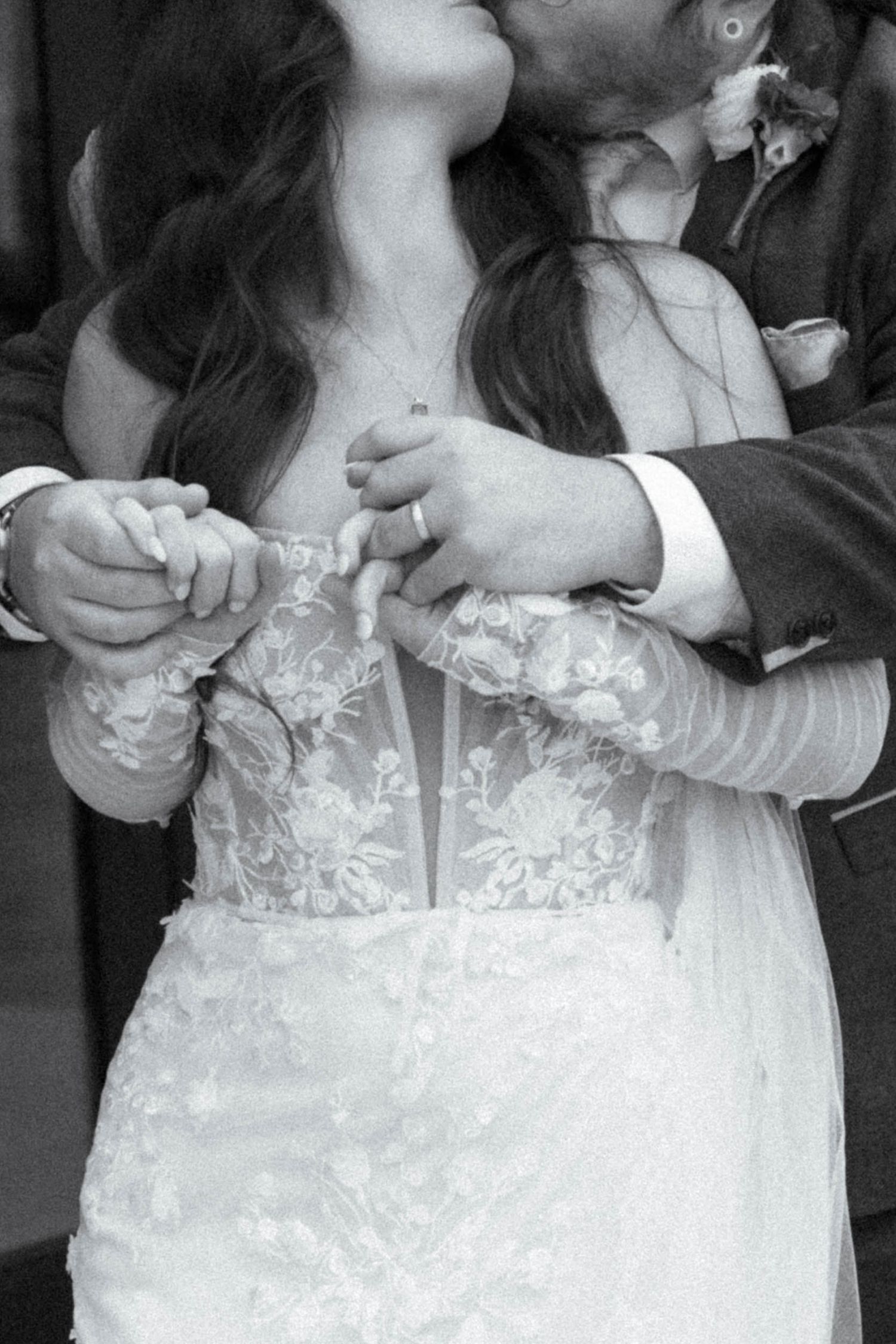 Close-up details of intricate lace bodice on white wedding gown.