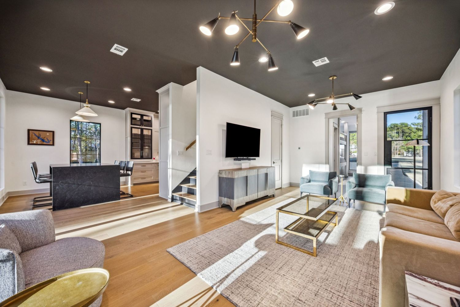 Long hallway with dark ceiling, recessed lighting, and hardwood flooring.