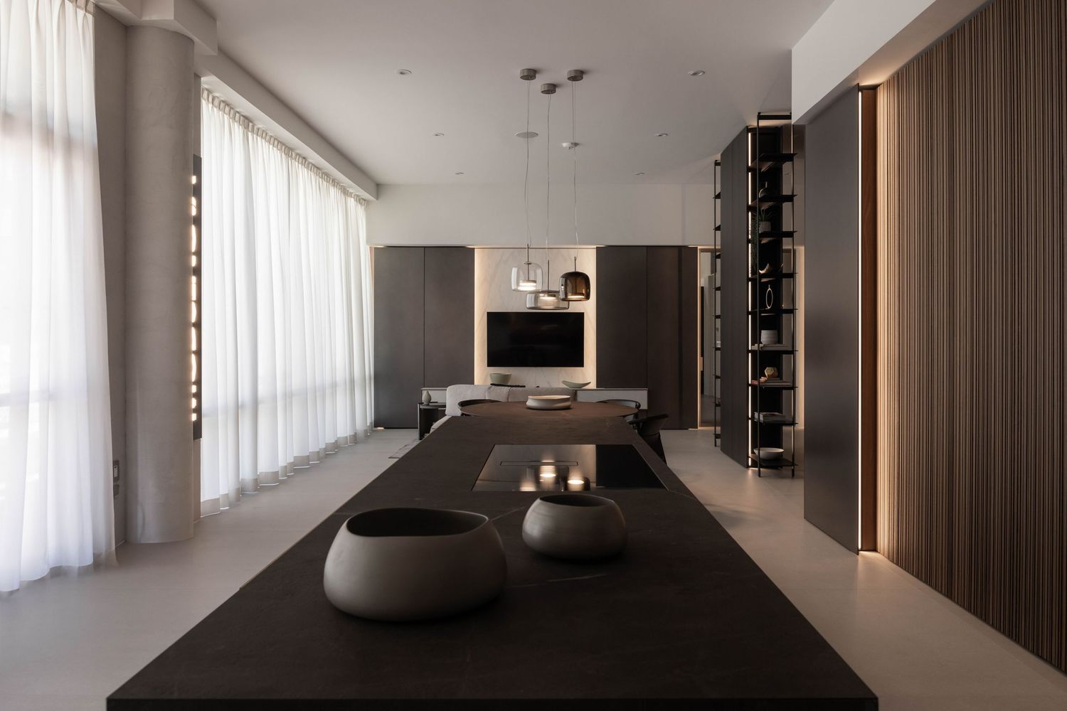 Contemporary open-plan living space with pendant lights and circular decorative elements.