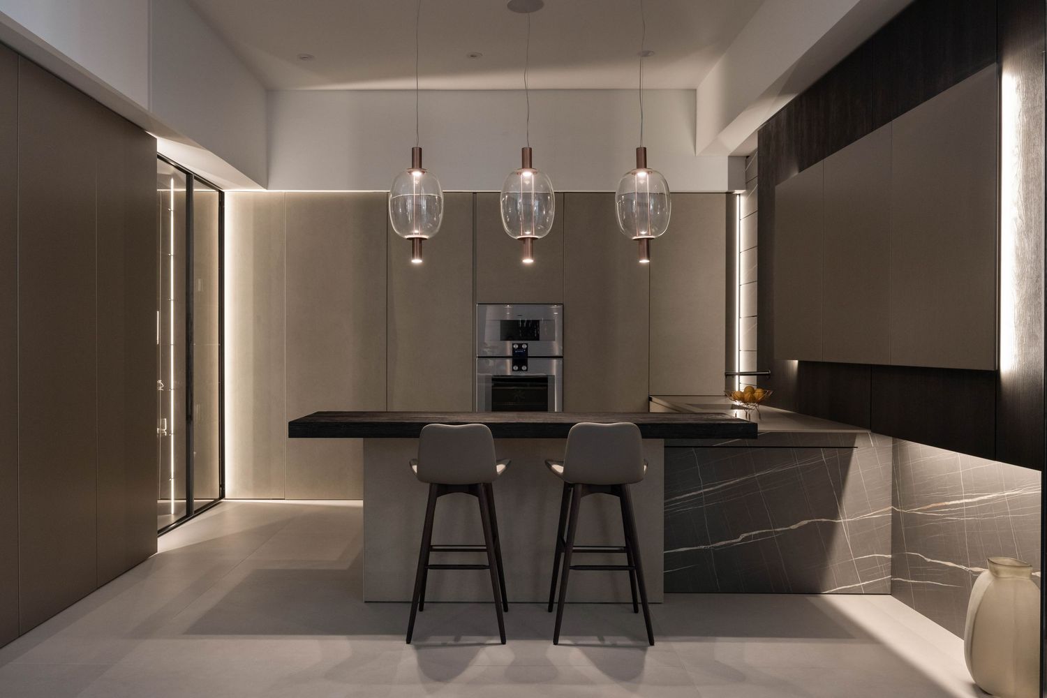 Modern minimalist dining area with round wooden table, black chairs, and pendant lighting in neutral tones.
