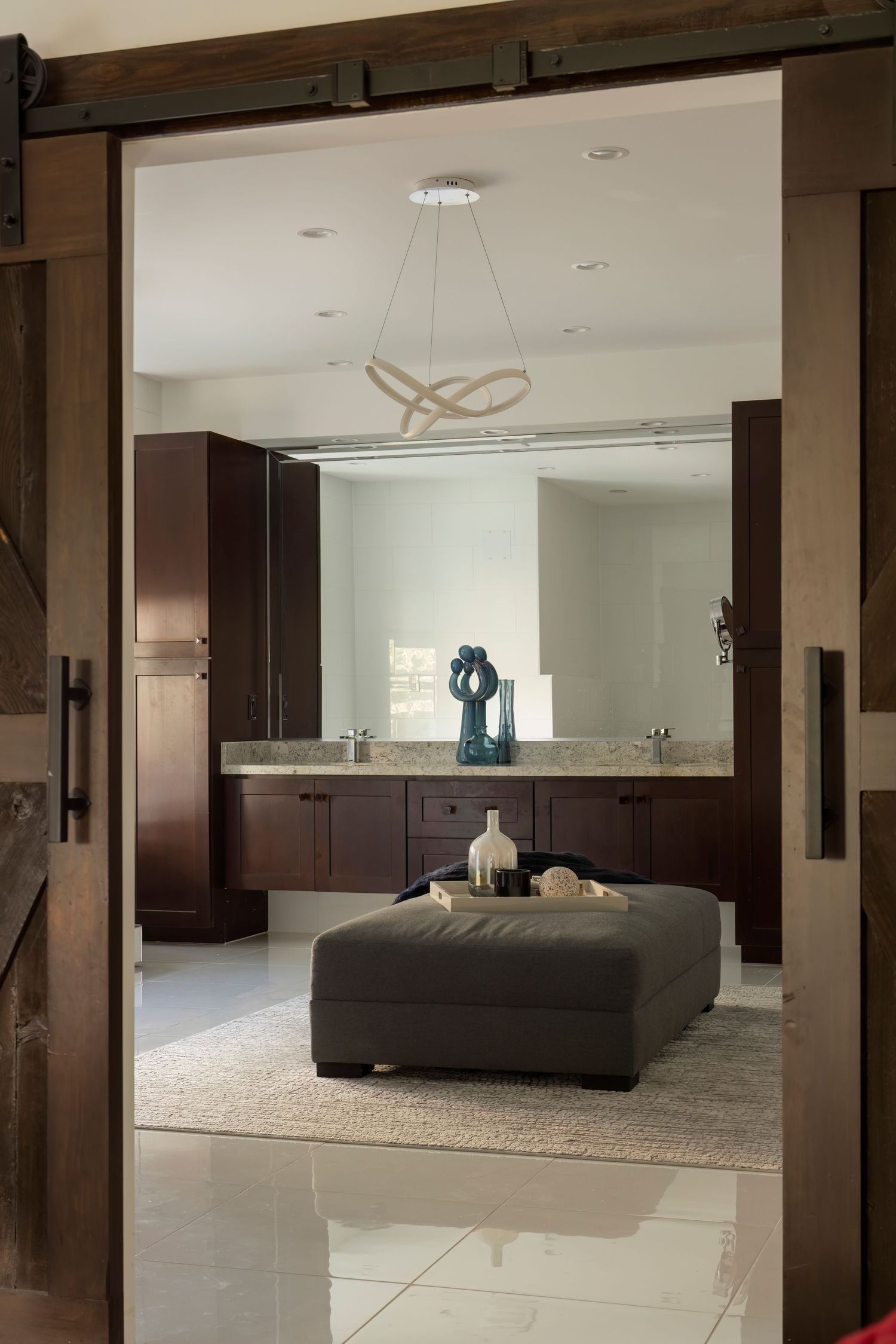 Elegant living room with dark wooden beams and modern furniture viewed through doorway frames.