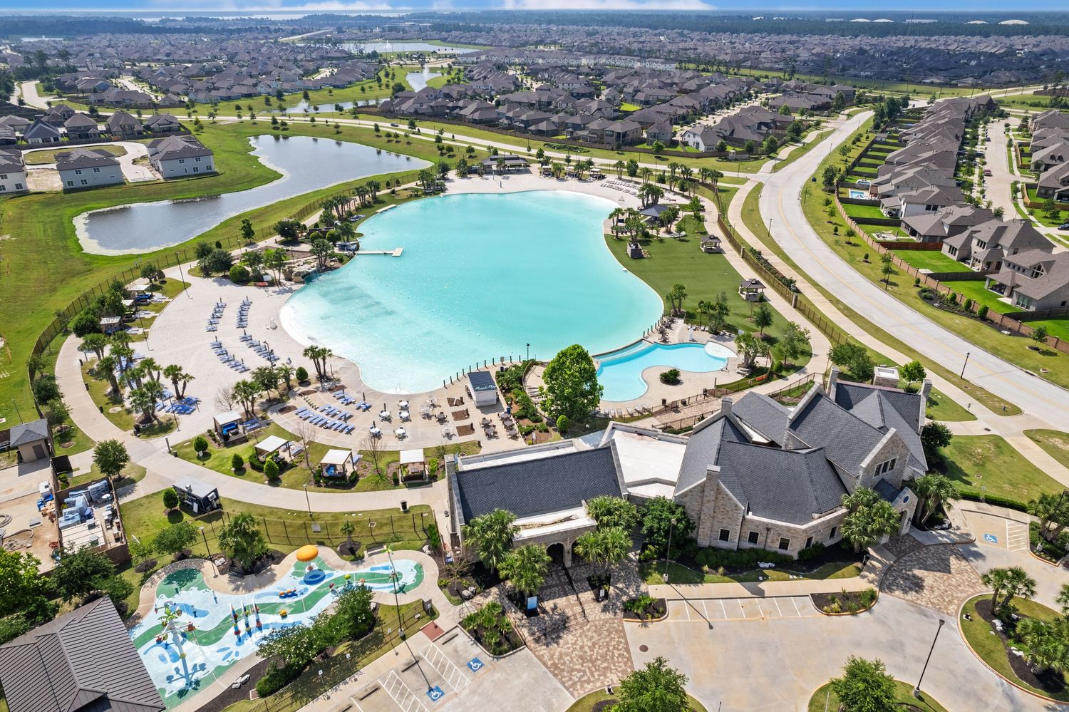 Aerial view of luxury residential community with swimming pools, curved roads, and landscaped grounds.