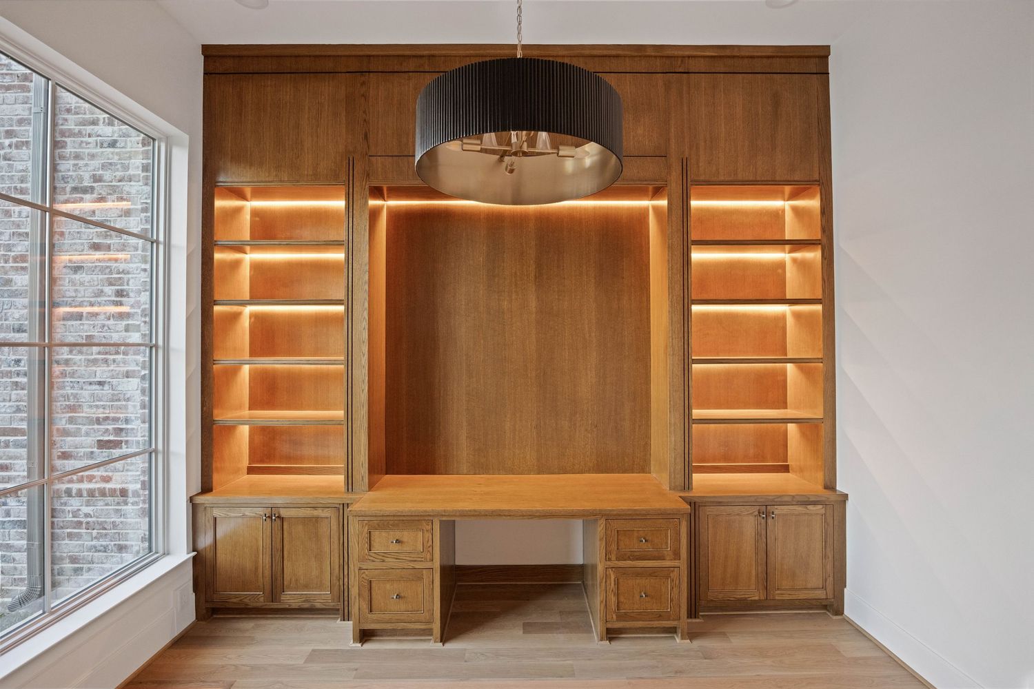 Custom wood built-in shelving with integrated LED lighting and display spaces.