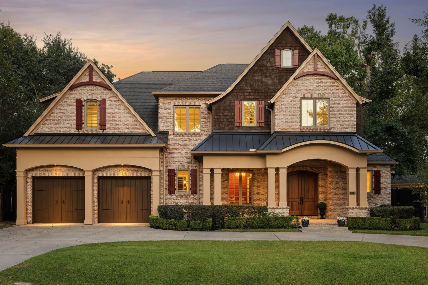 Exterior view of a craftsman-style luxury home with attached garage at dusk.