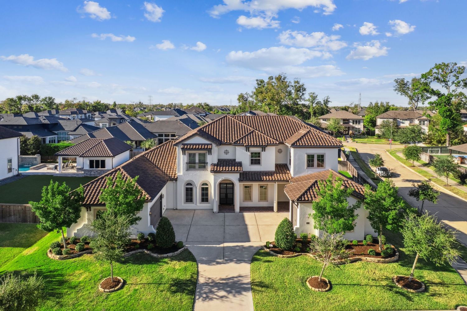 Drone shot of upscale residential neighborhood with Mediterranean-style homes.