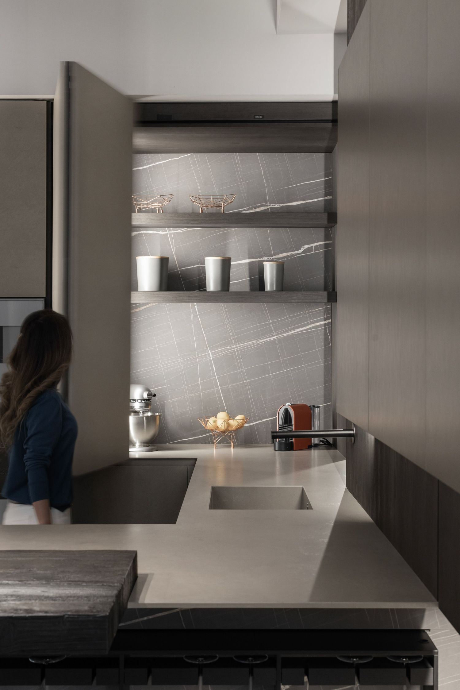 Sleek kitchen interior with grey countertops and minimalist storage solutions.