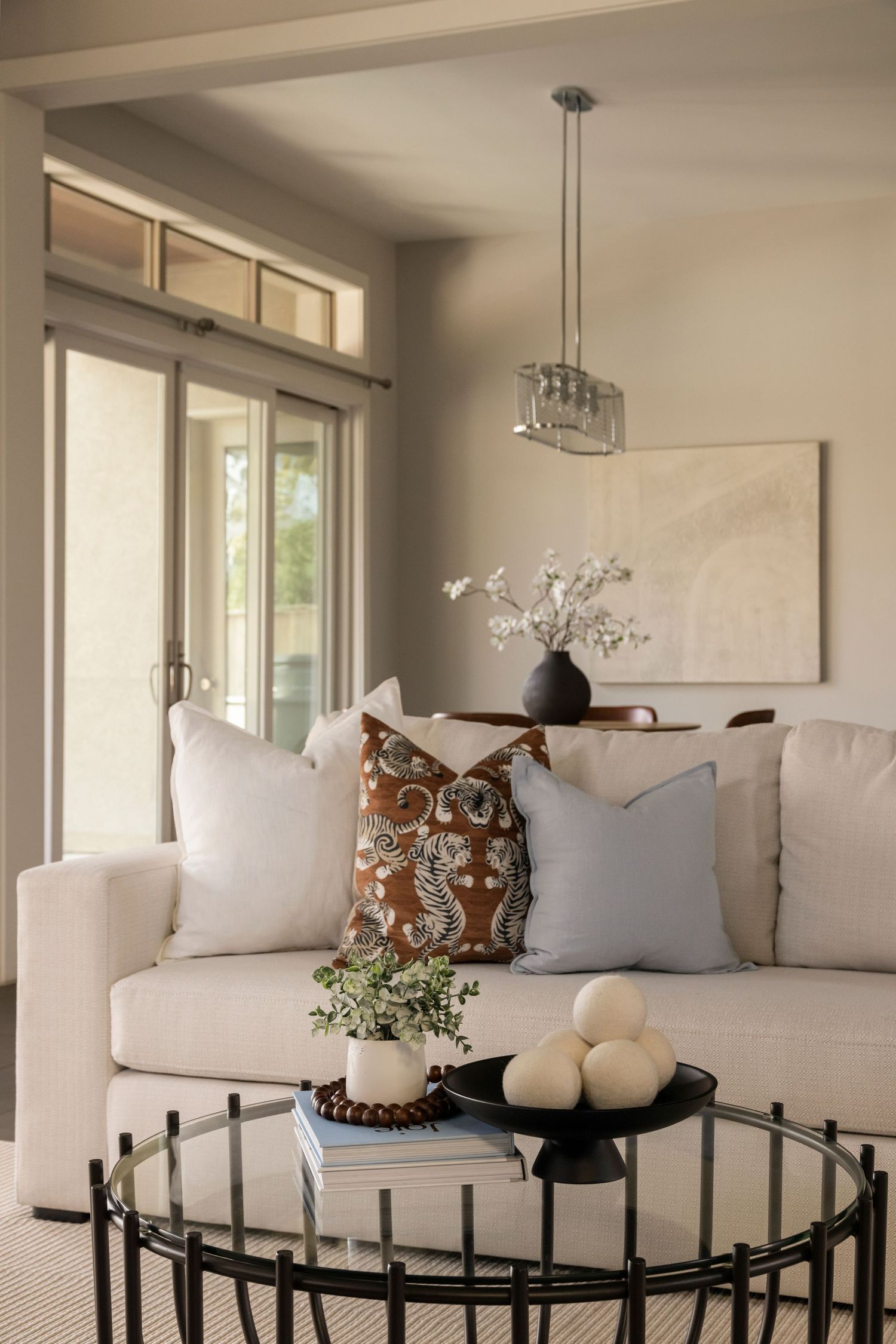 Modern living room with white sofa, decorative pillows, and black accent table.