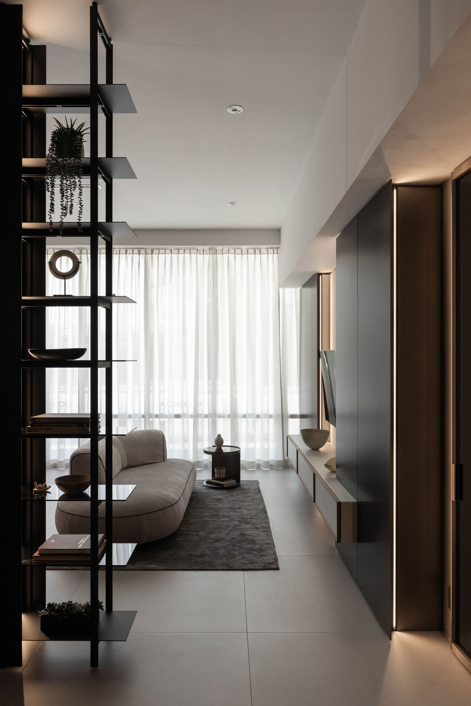 Spacious modern apartment interior with floor-to-ceiling windows and minimalist furniture.
