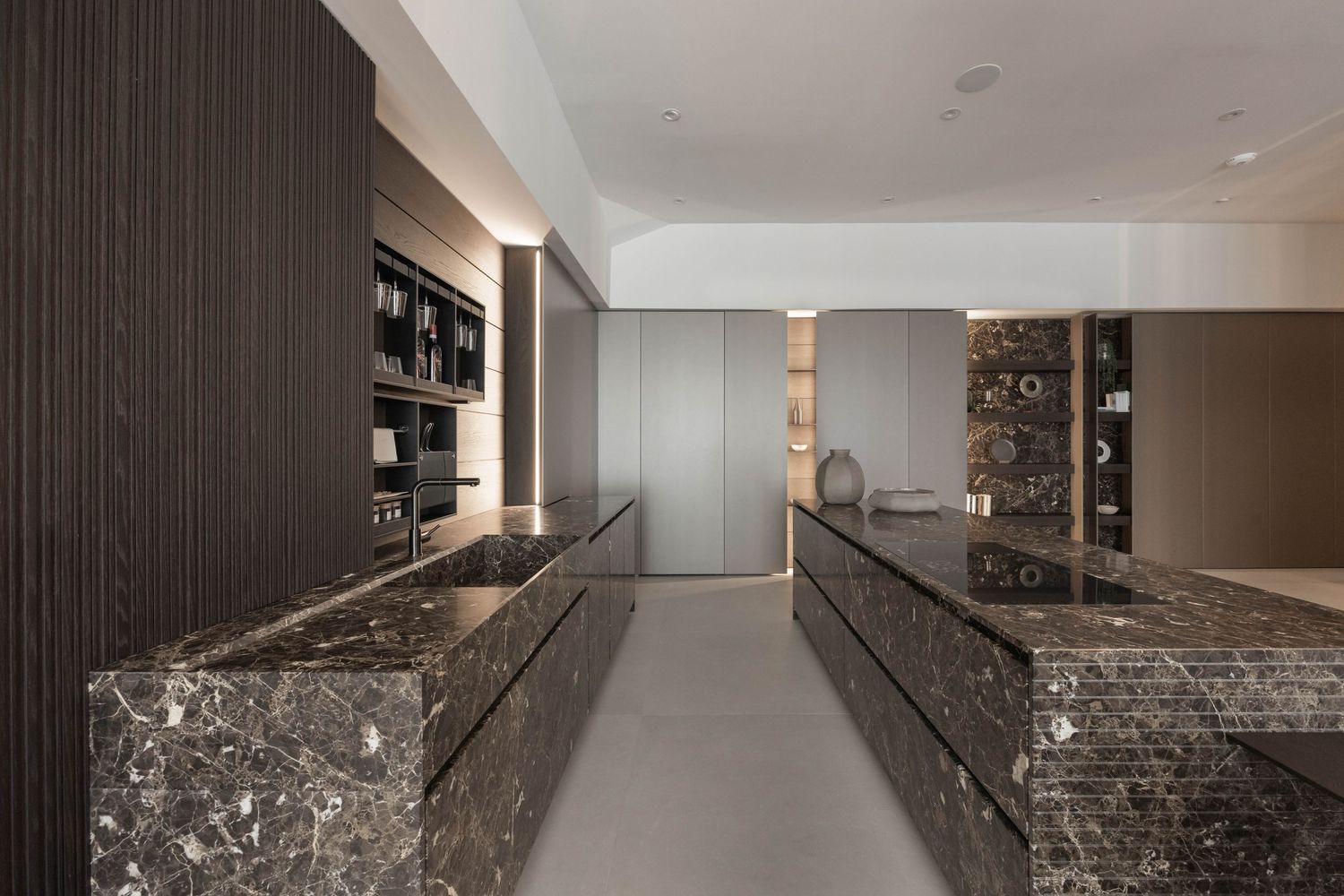 Dark marble accents complement the sleek modern kitchen design with hidden storage solutions.