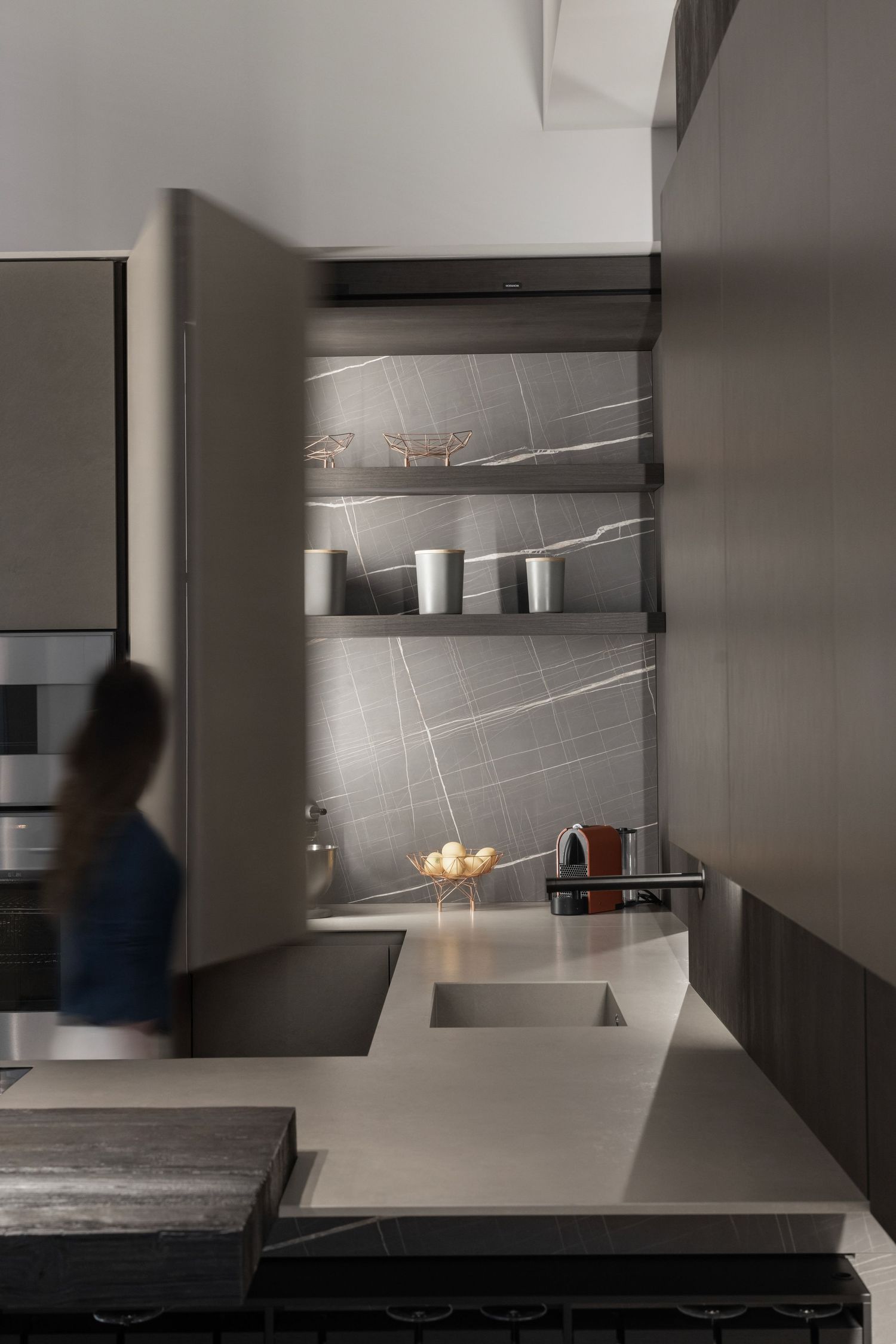 Sleek kitchen design with geometric lighting and modern appliances.