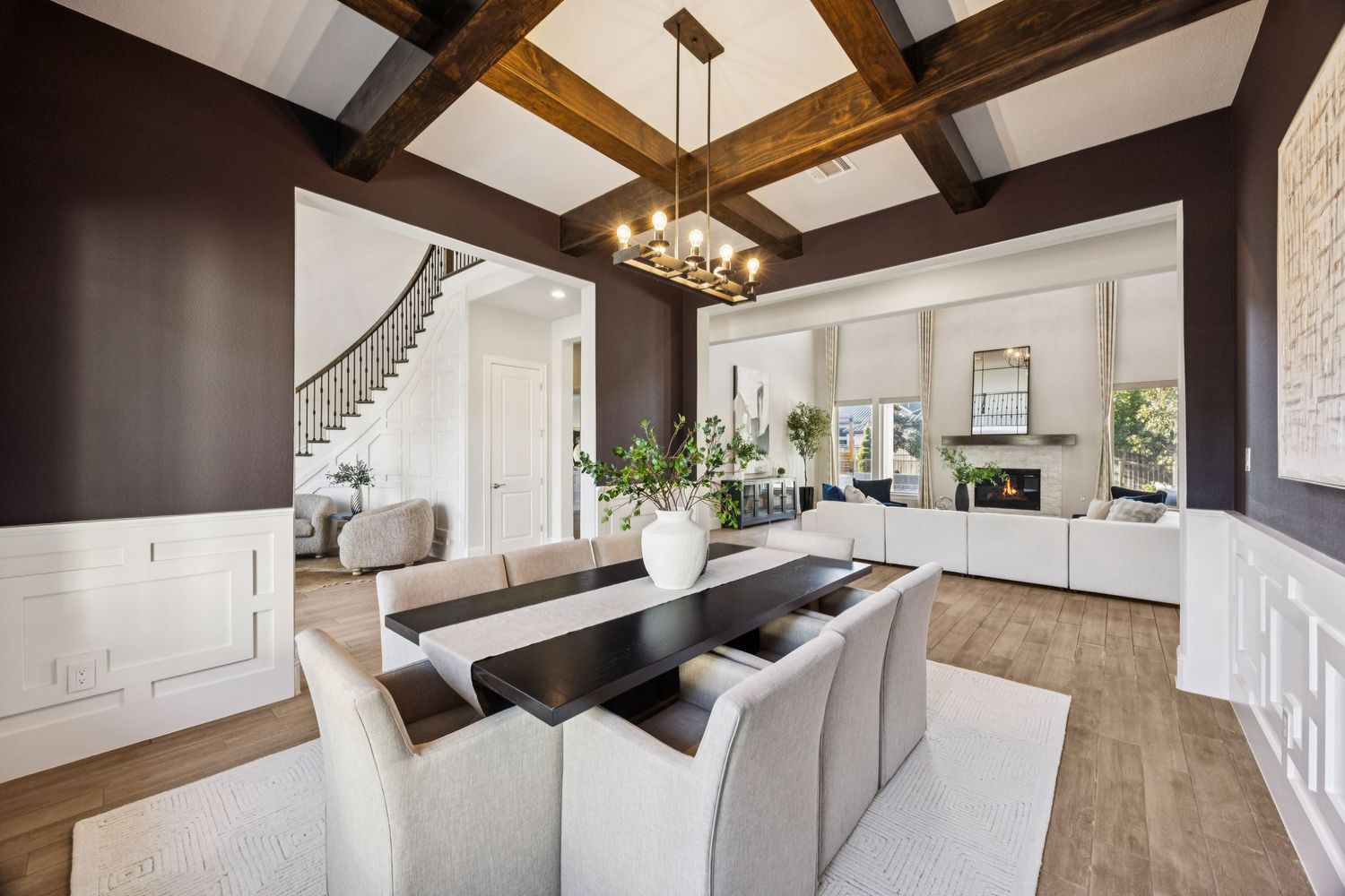 Spacious living room featuring exposed wooden ceiling beams, white walls, and contemporary furniture.
