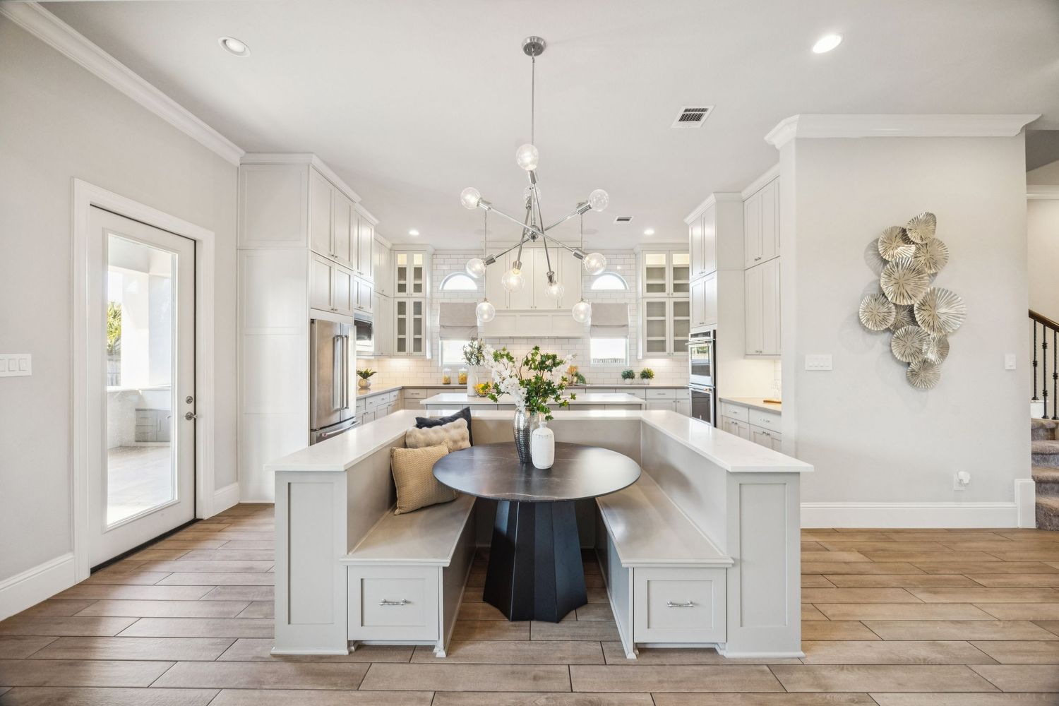 Bright interior hallway with white walls, hardwood flooring, and modern light fixtures.