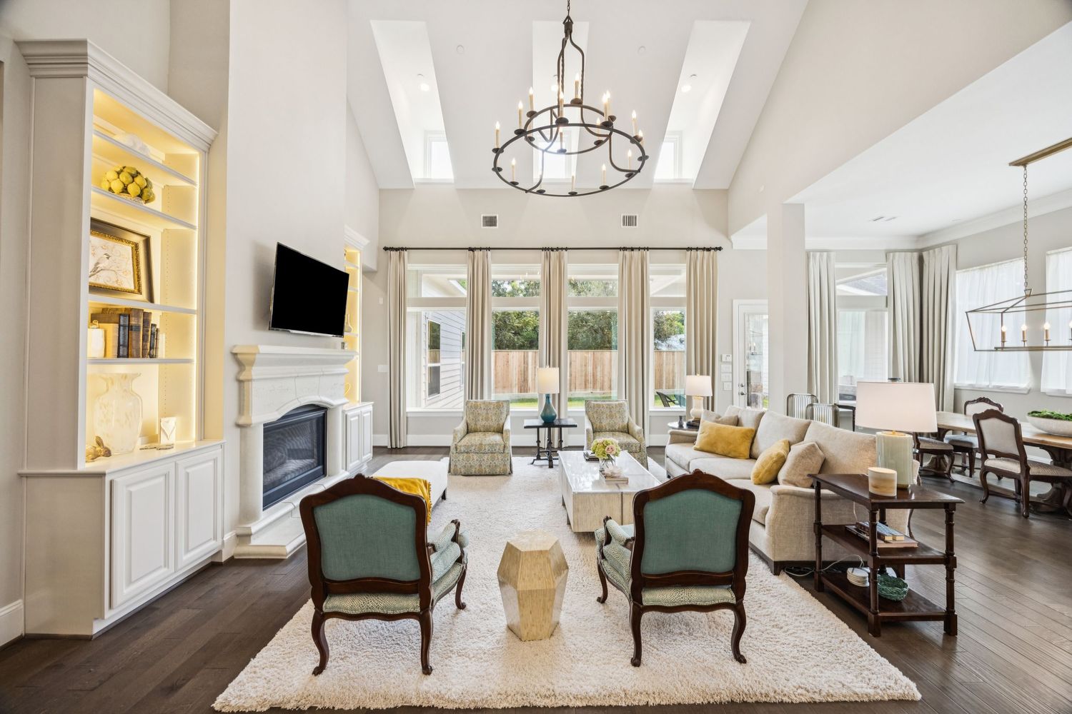 Open concept living space with traditional furniture, high ceilings, and modern lighting fixtures.