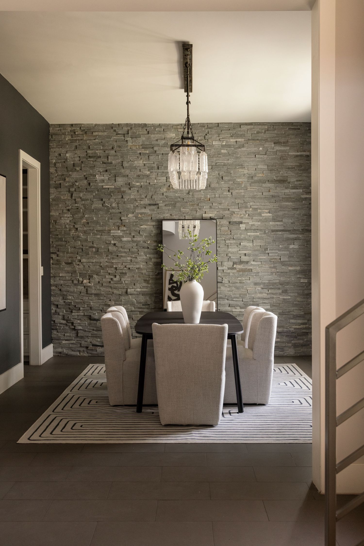 Living room with stone accent wall, modern furniture, and geometric pattern carpet.