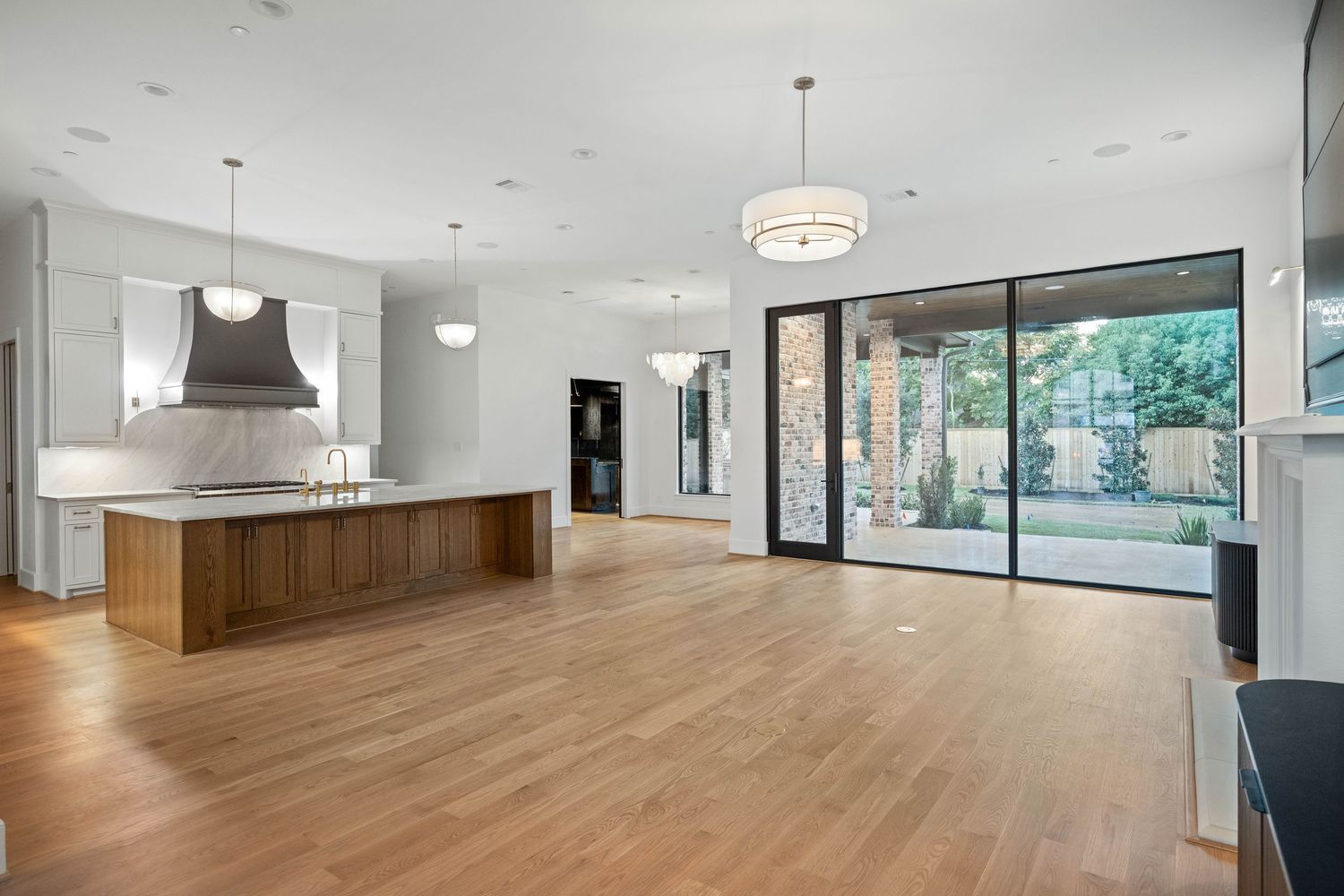 Spacious open concept living area with hardwood floors and large windows providing natural light.
