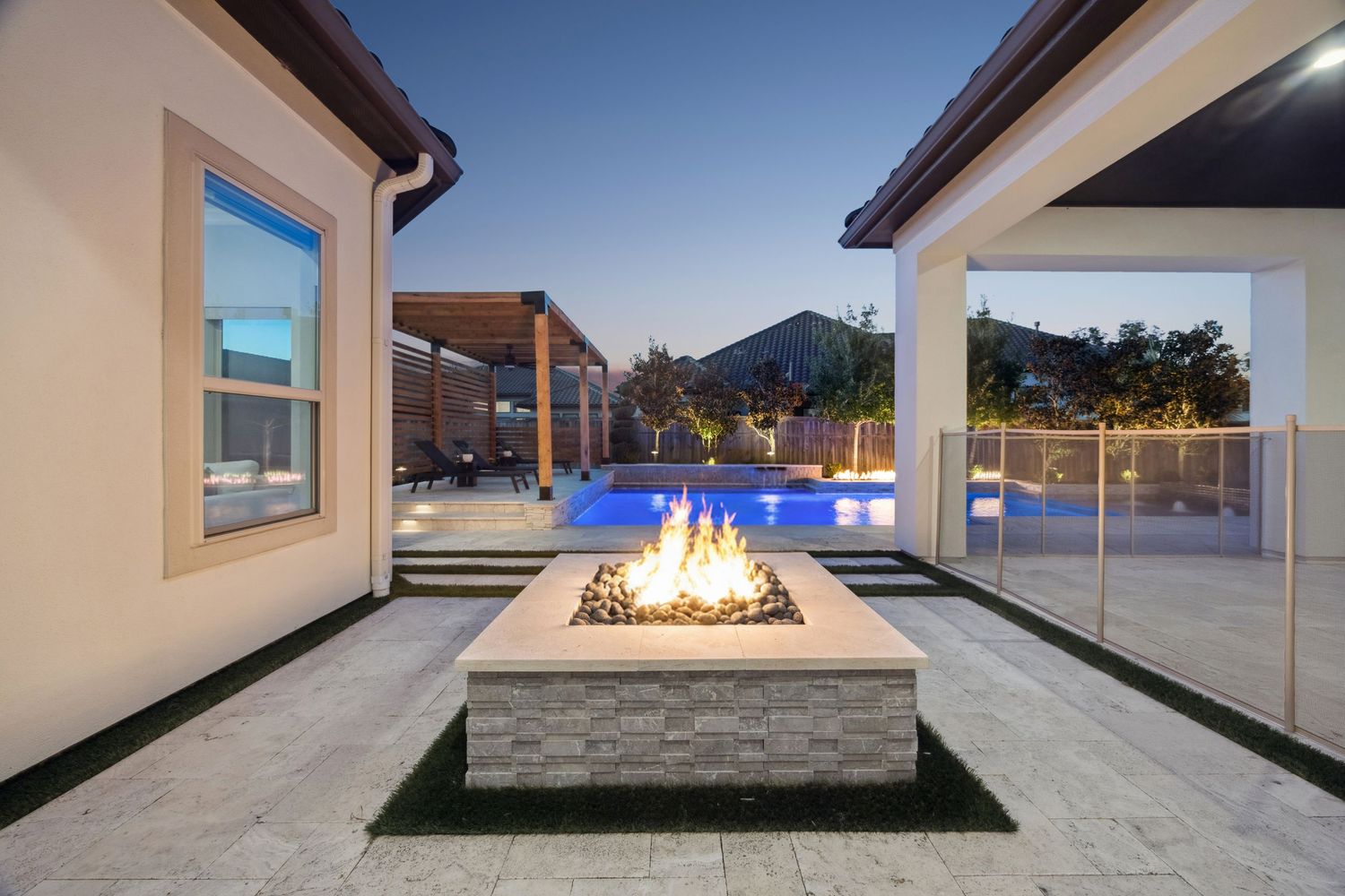 Outdoor living space with built-in fire pit and mountain views at dusk.