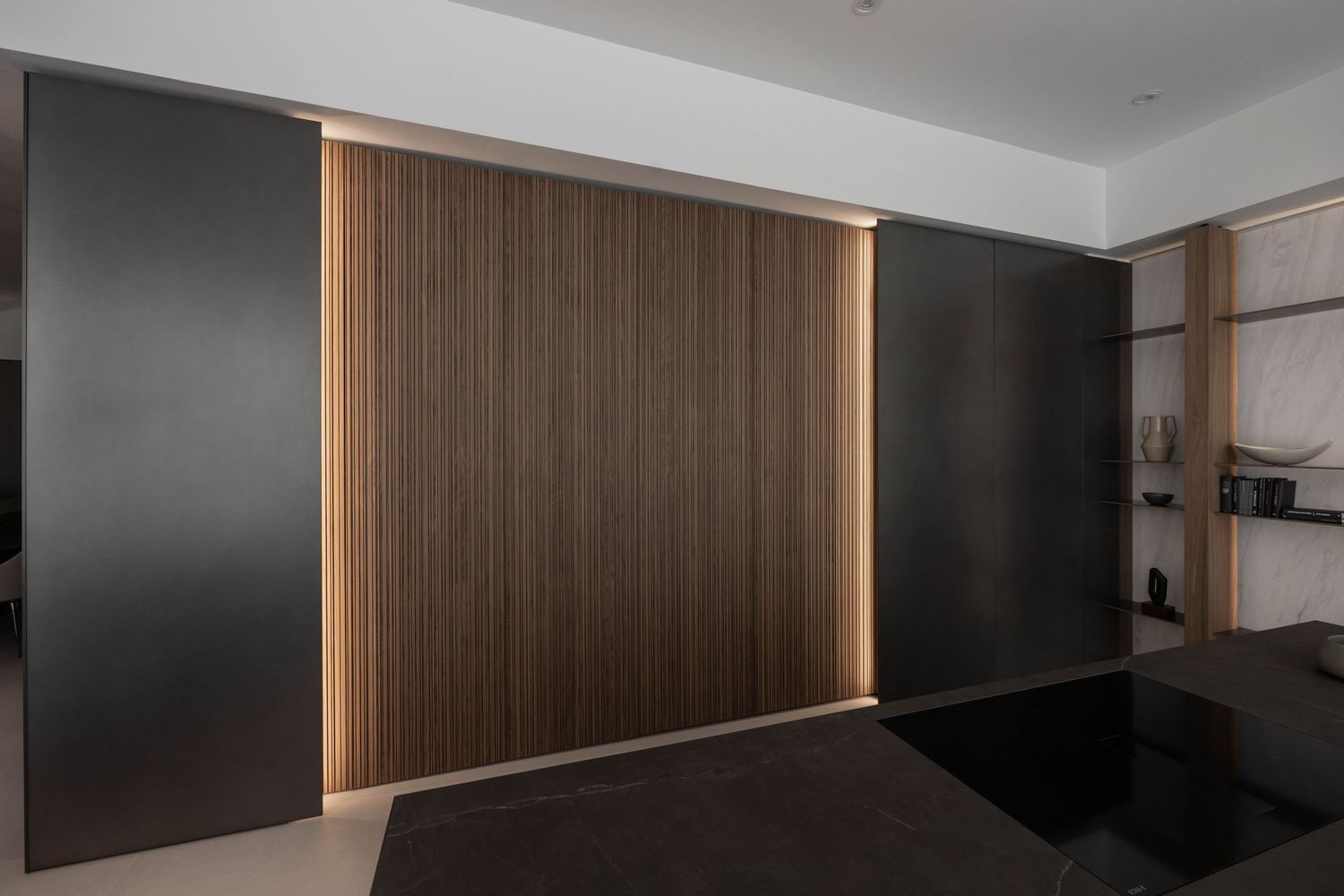 Minimalist interior featuring dark accent walls and wooden panels with ambient lighting.