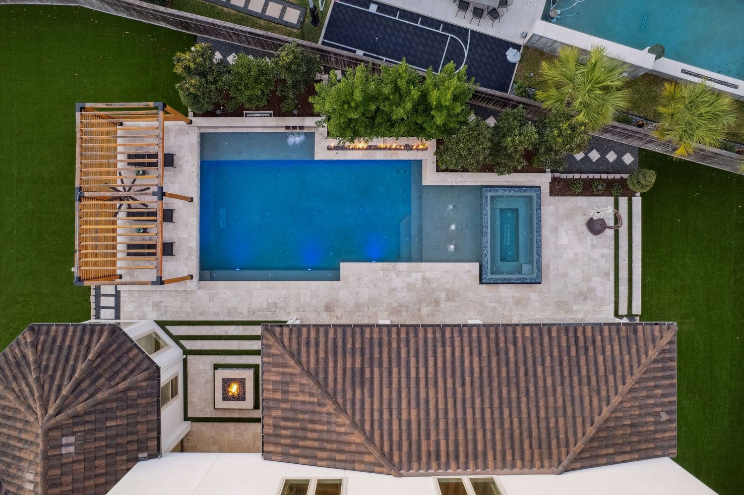 Aerial view of luxury property showcasing pool, landscaping, and outdoor entertainment areas.
