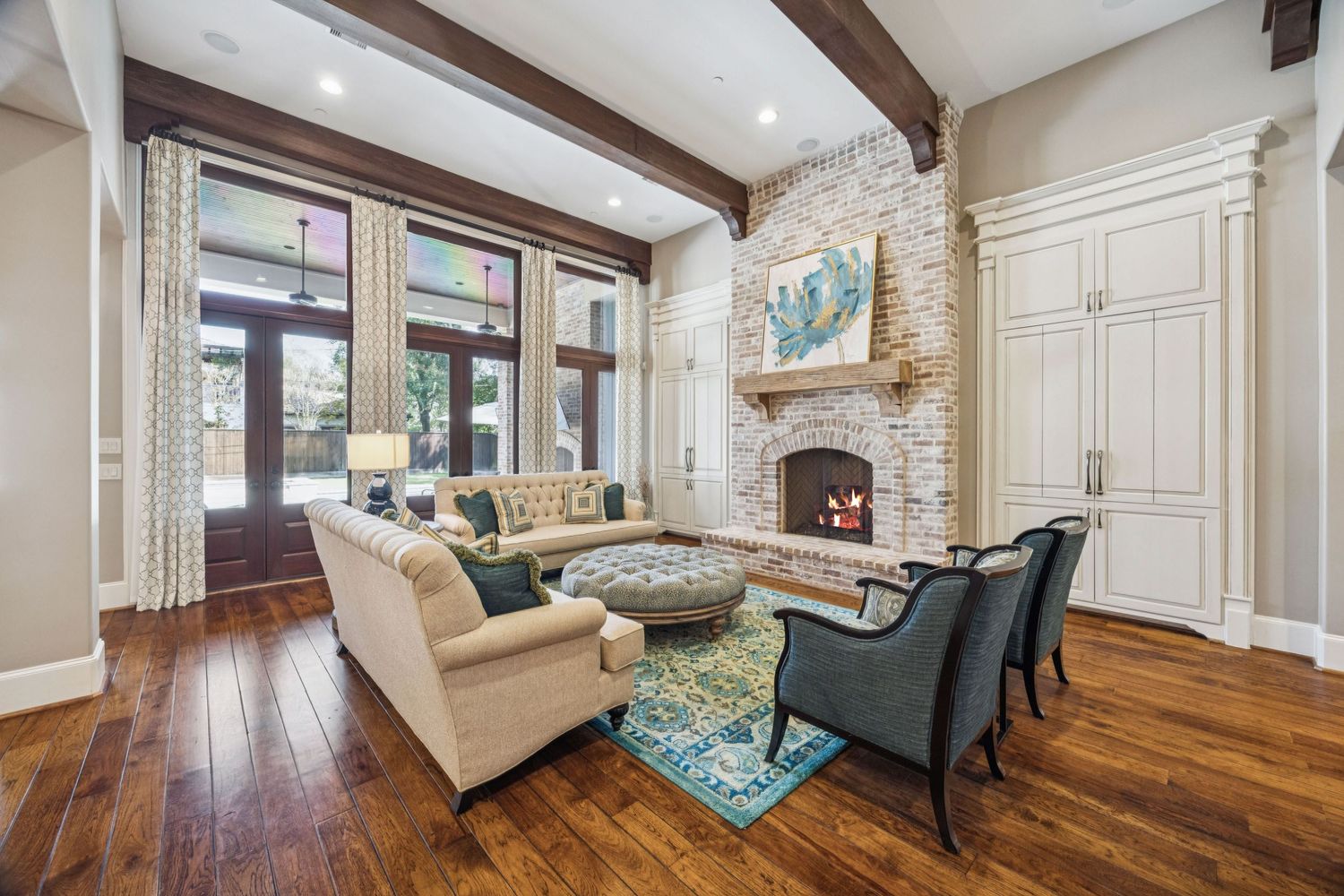 Luxurious living space with exposed wooden beams, hardwood floors, and classic furniture.