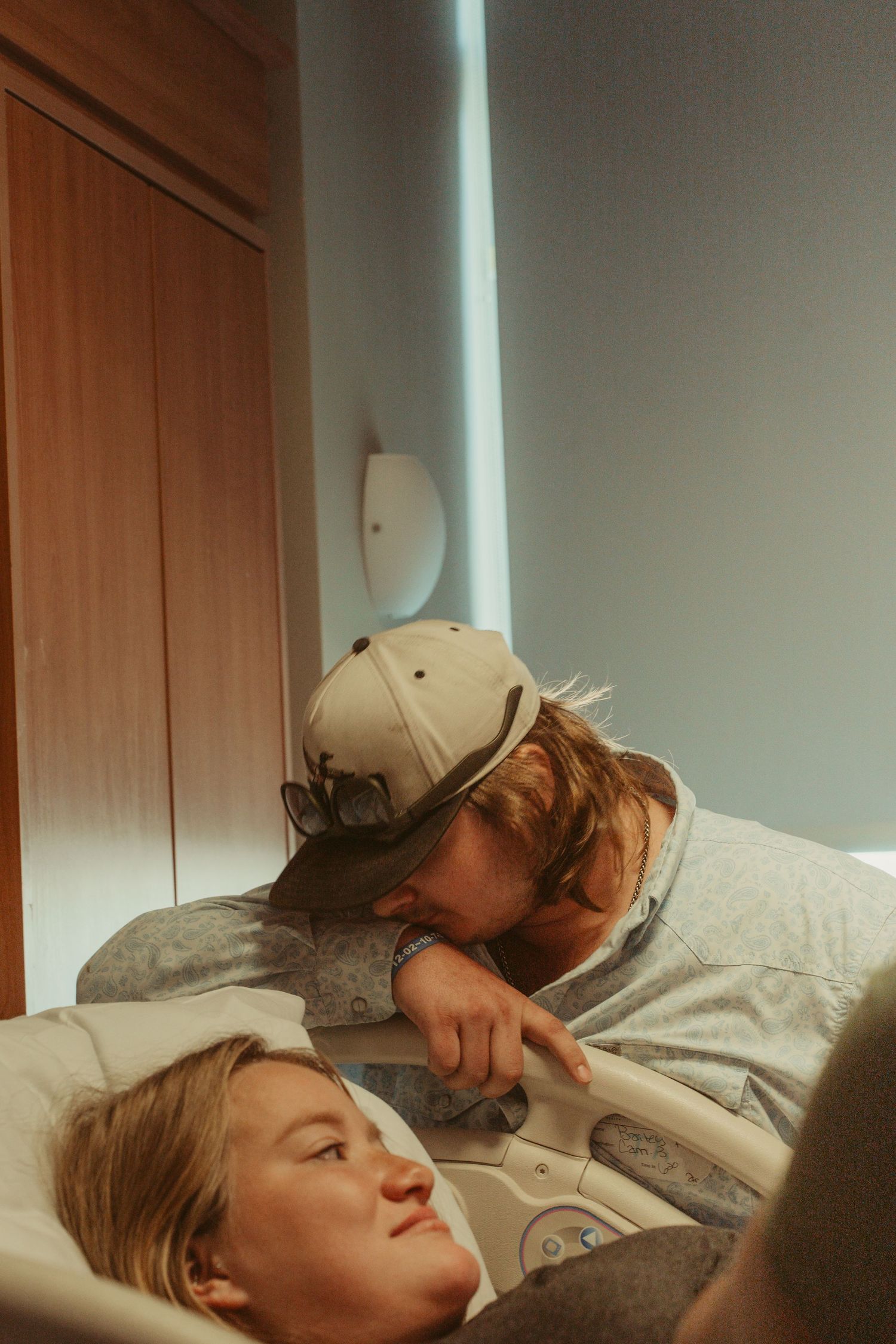 A couple shares a tender moment in a hospital room during labor.