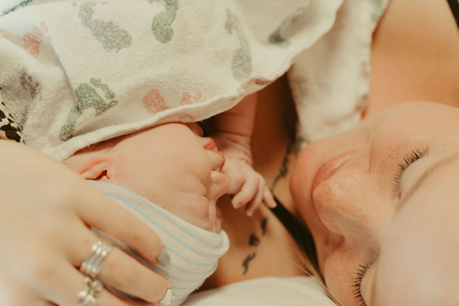 A mother holds her newborn baby close to her face after birth.