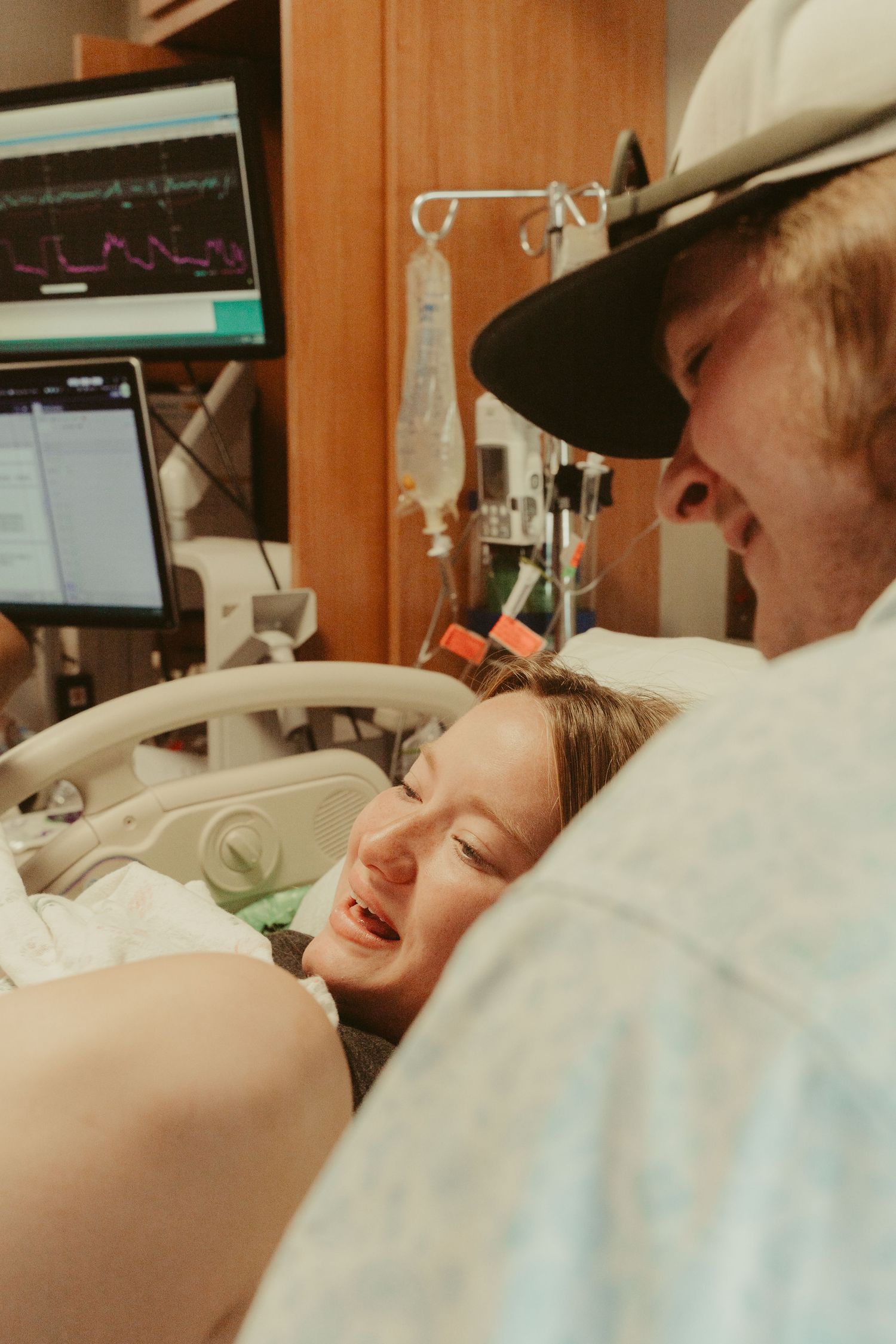 A woman in labor smiles at her partner in a hospital delivery room.
