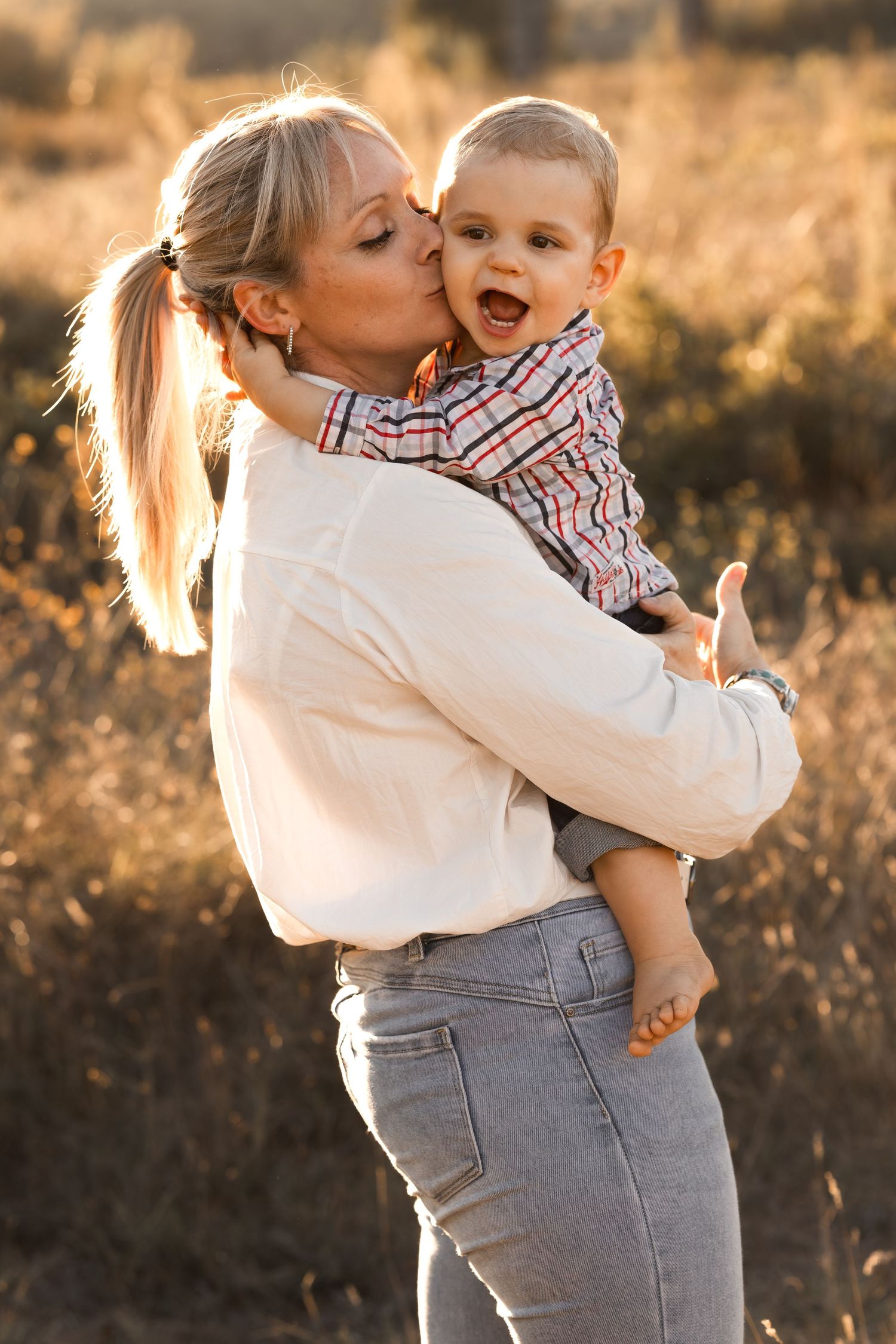 Une maman blonde embrasse tendrement son fils à Cazouls-lès-Béziers à l'occasion d'une séance photo en famille.