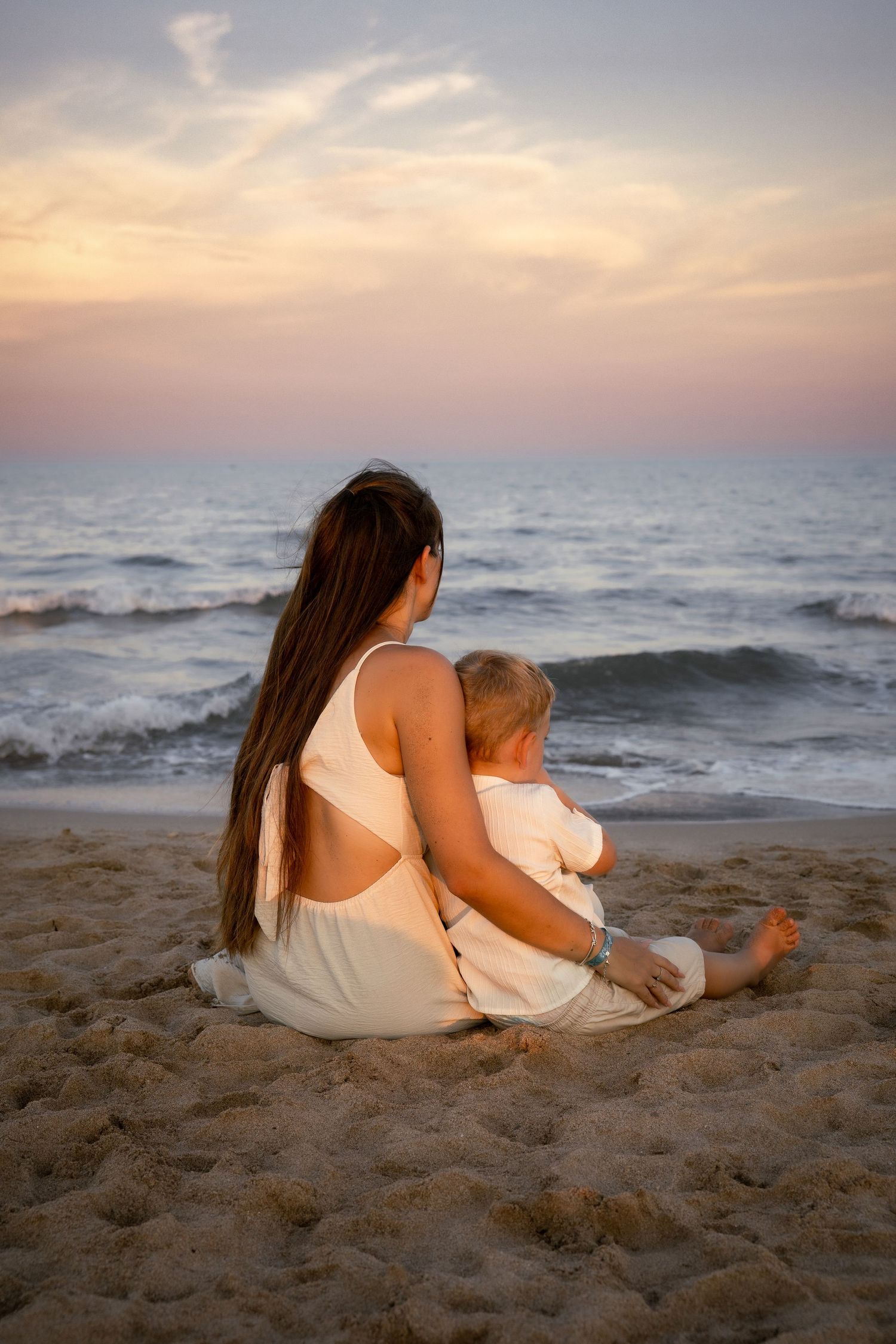 Photo d'une mère et son fils face au coucher de soleil en bord de mer à Valras-Plage plage lors d'une séance famille. Photographe lifestyle.