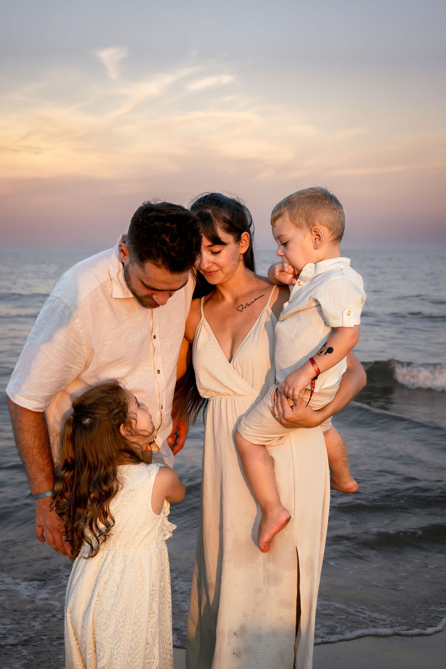 Portrait de famille à Vendres plage. Photo lifestyle au coucher de soleil proche de Valras plage. Une famille se câline en bord de mer.