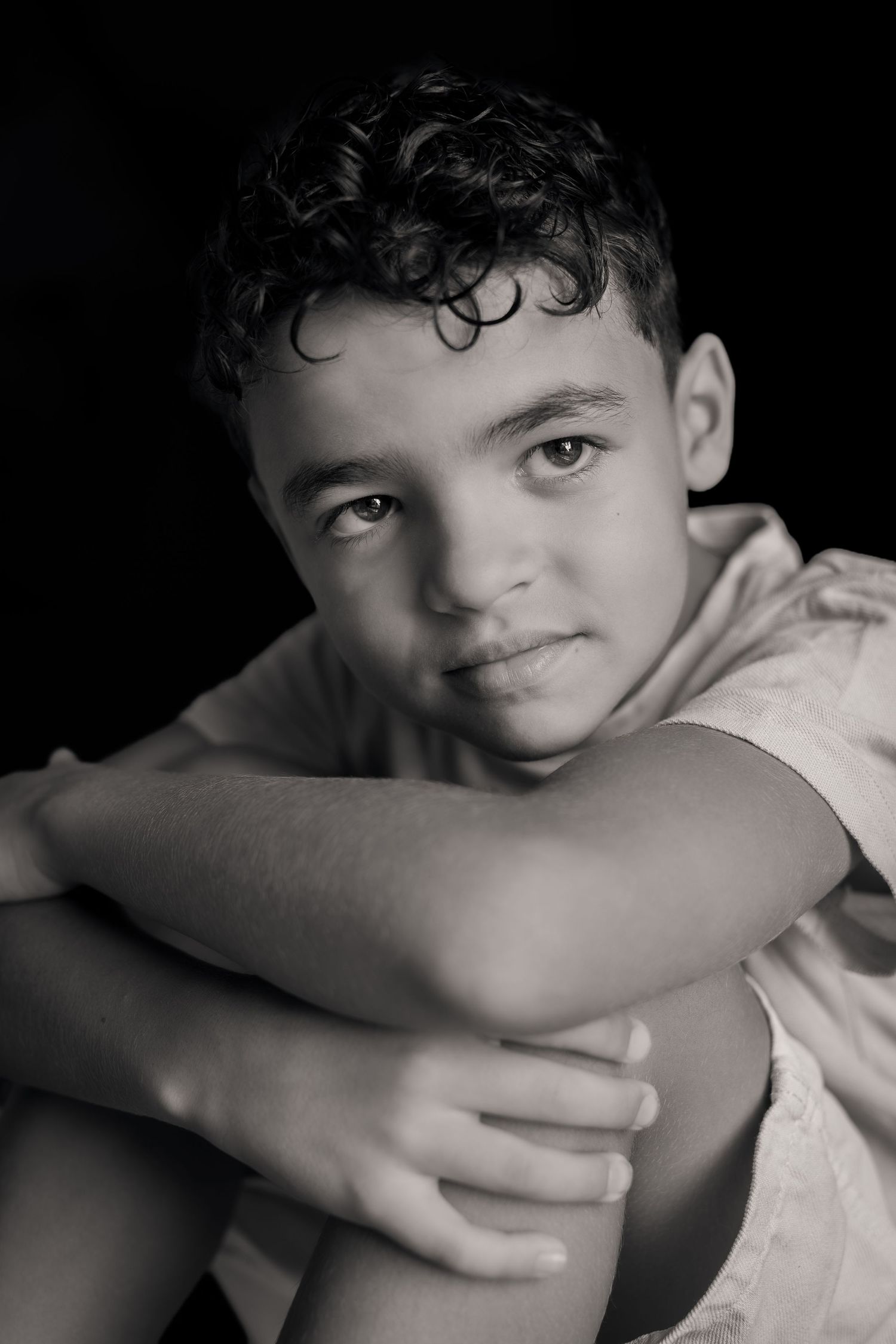 Photographie en noir et blanc, garçon métisse cheveux bouclés. Photographe spécialisée dans le portrait d'enfant à Puimisson et alentours.