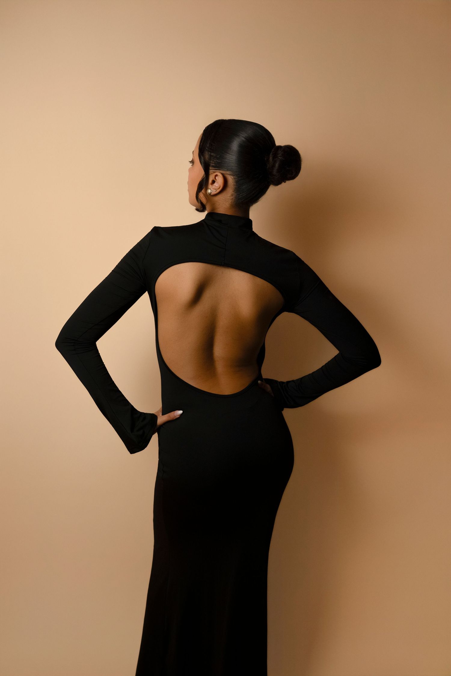 A series of artistic photographs showing a person in a black long dress posing against a beige background.