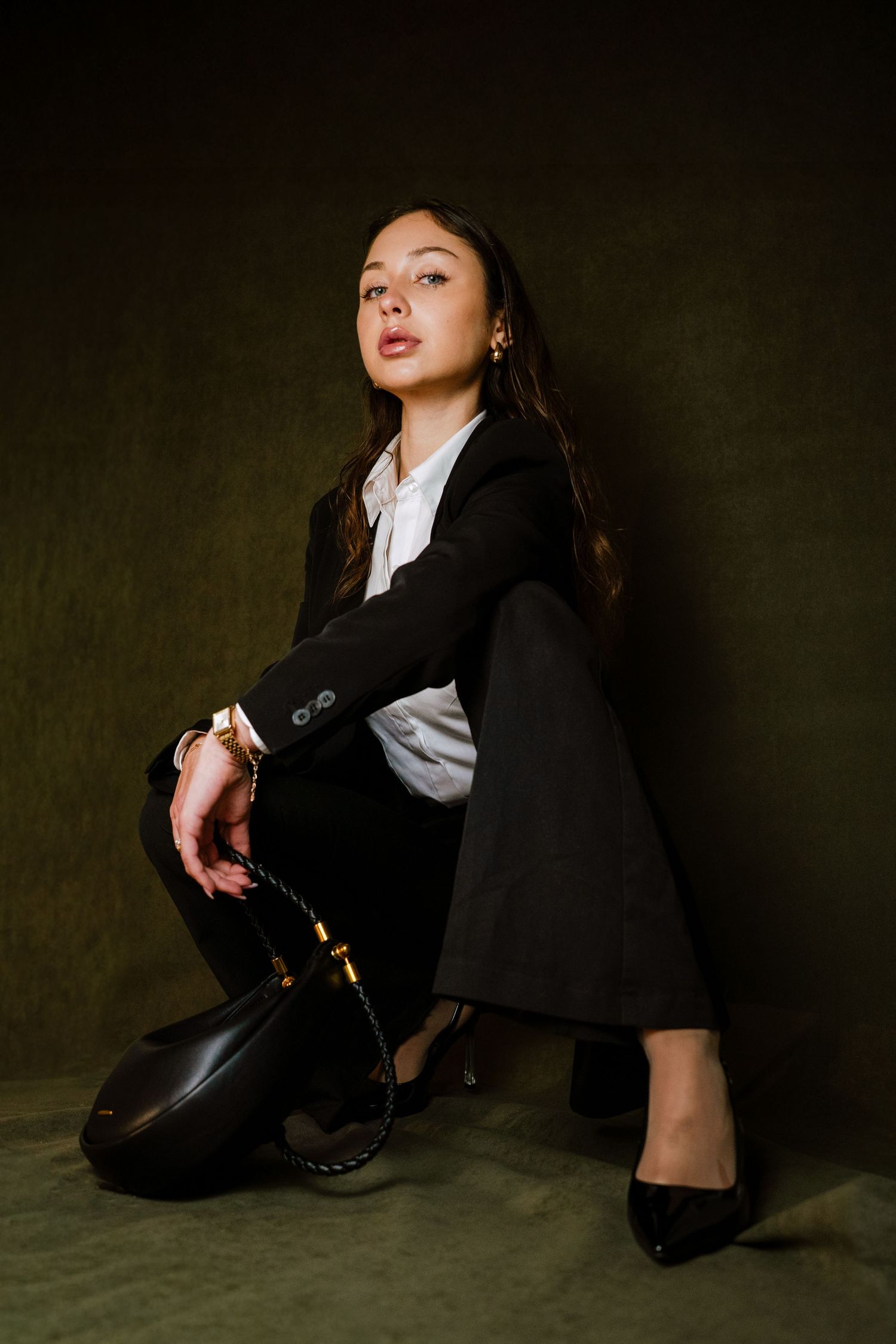 Branding and beauty portrait of a woman in black suit striking a dynamic pose i