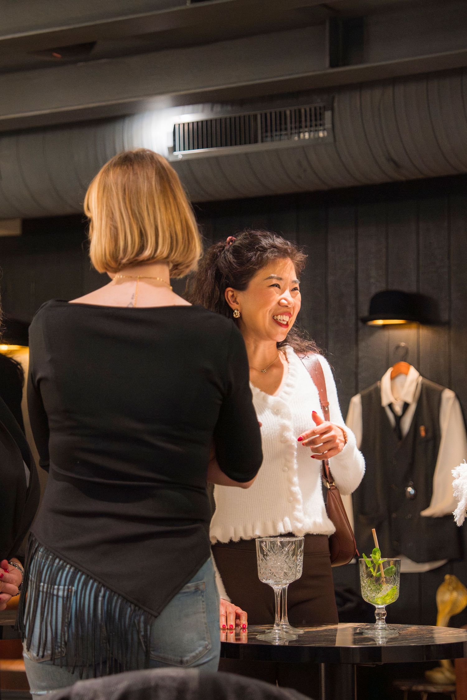 Friends enjoying drinks and laughter at a dimly lit bar, captured in a series of candid moments.