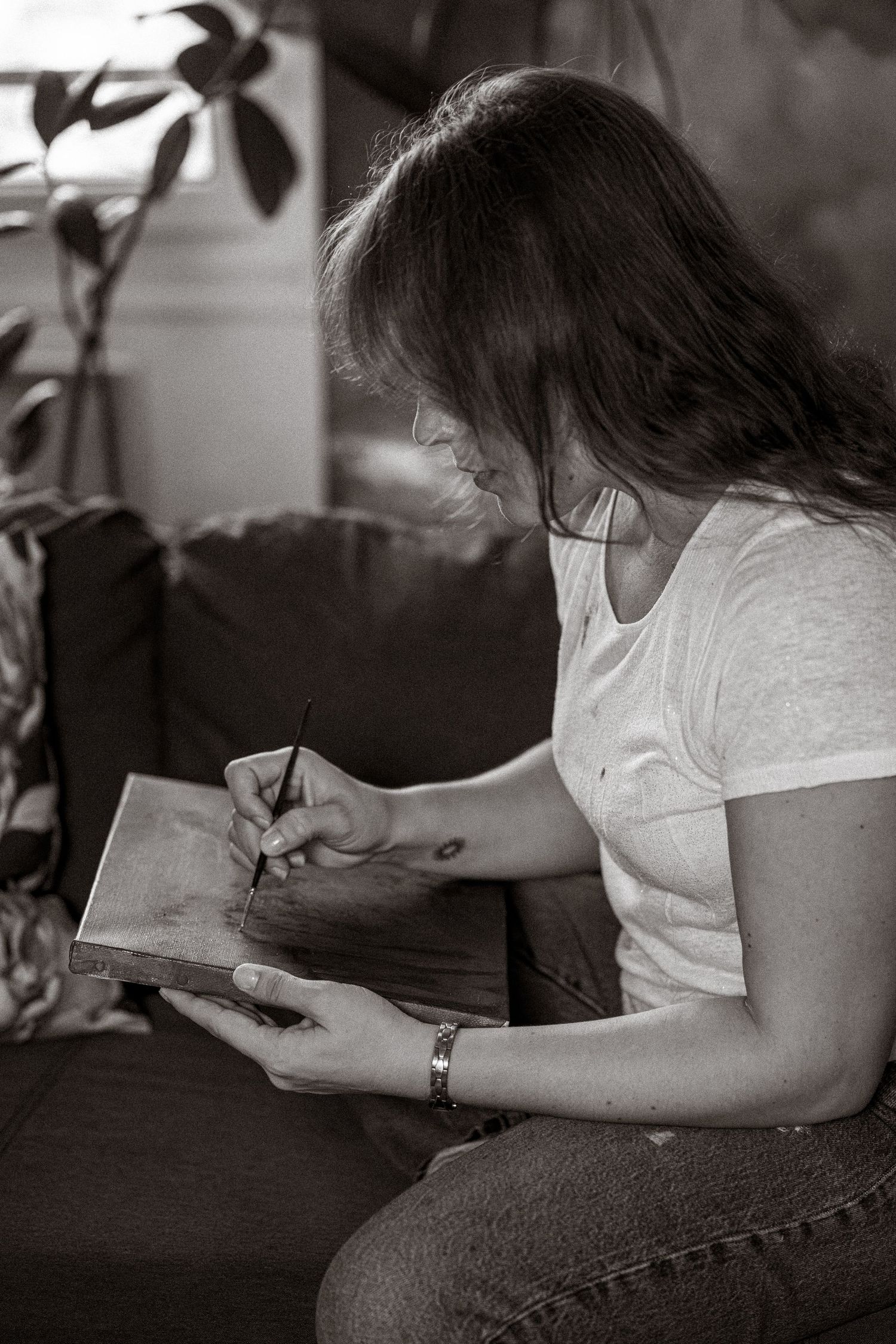 A series of black and white photos showing someone reading a book while reclining on a dark surface.