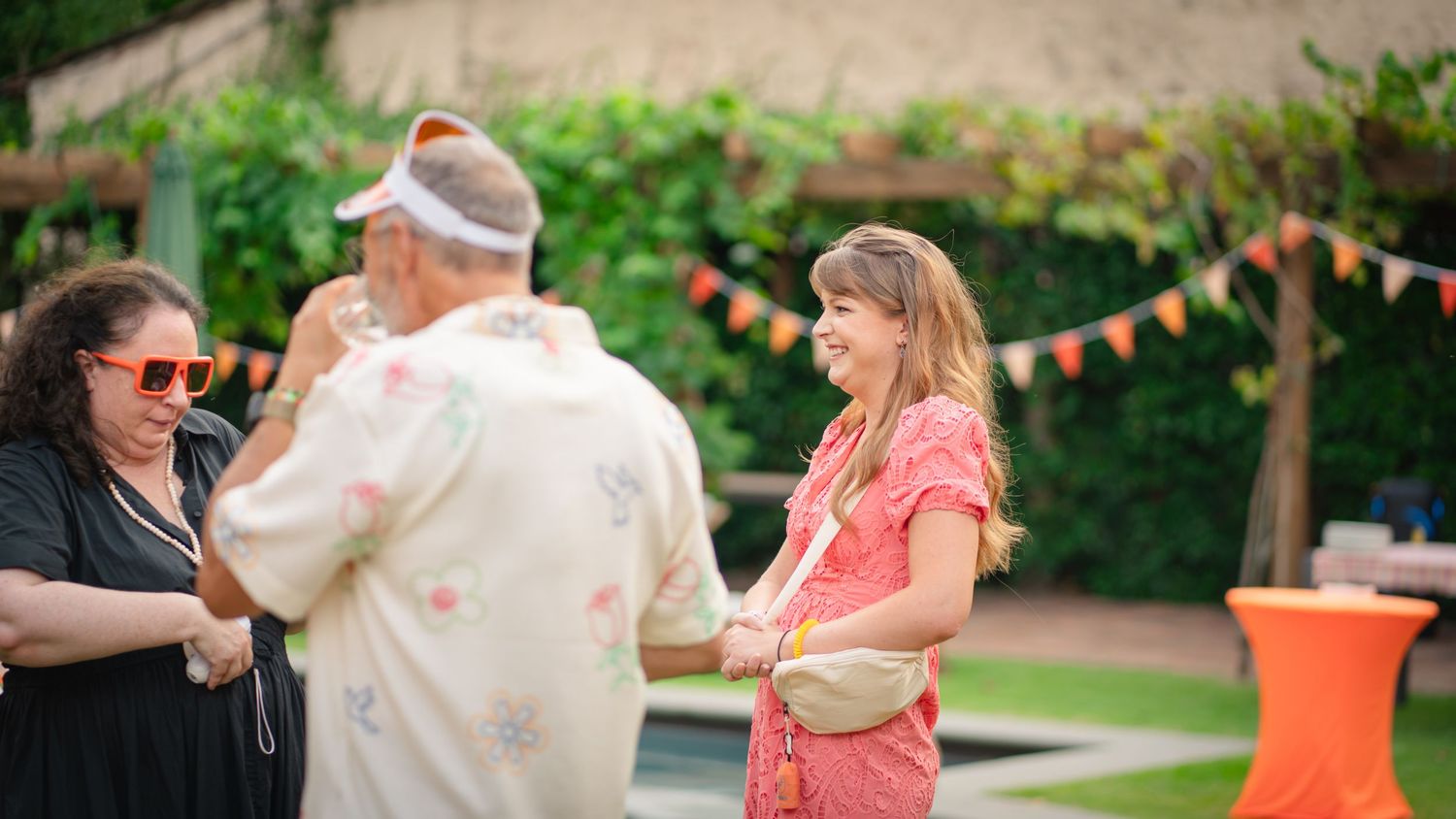 Outdoor party scene with festive bunting decorations and guests mingling in the Tuscan region