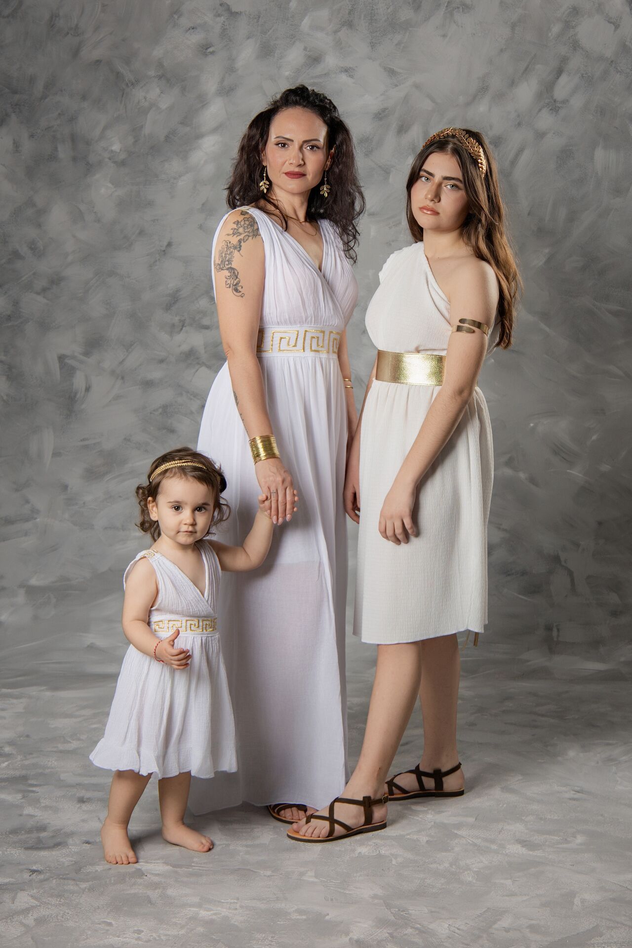 A series of studio portraits showing people in white dresses posing against a textured grey backdrop.