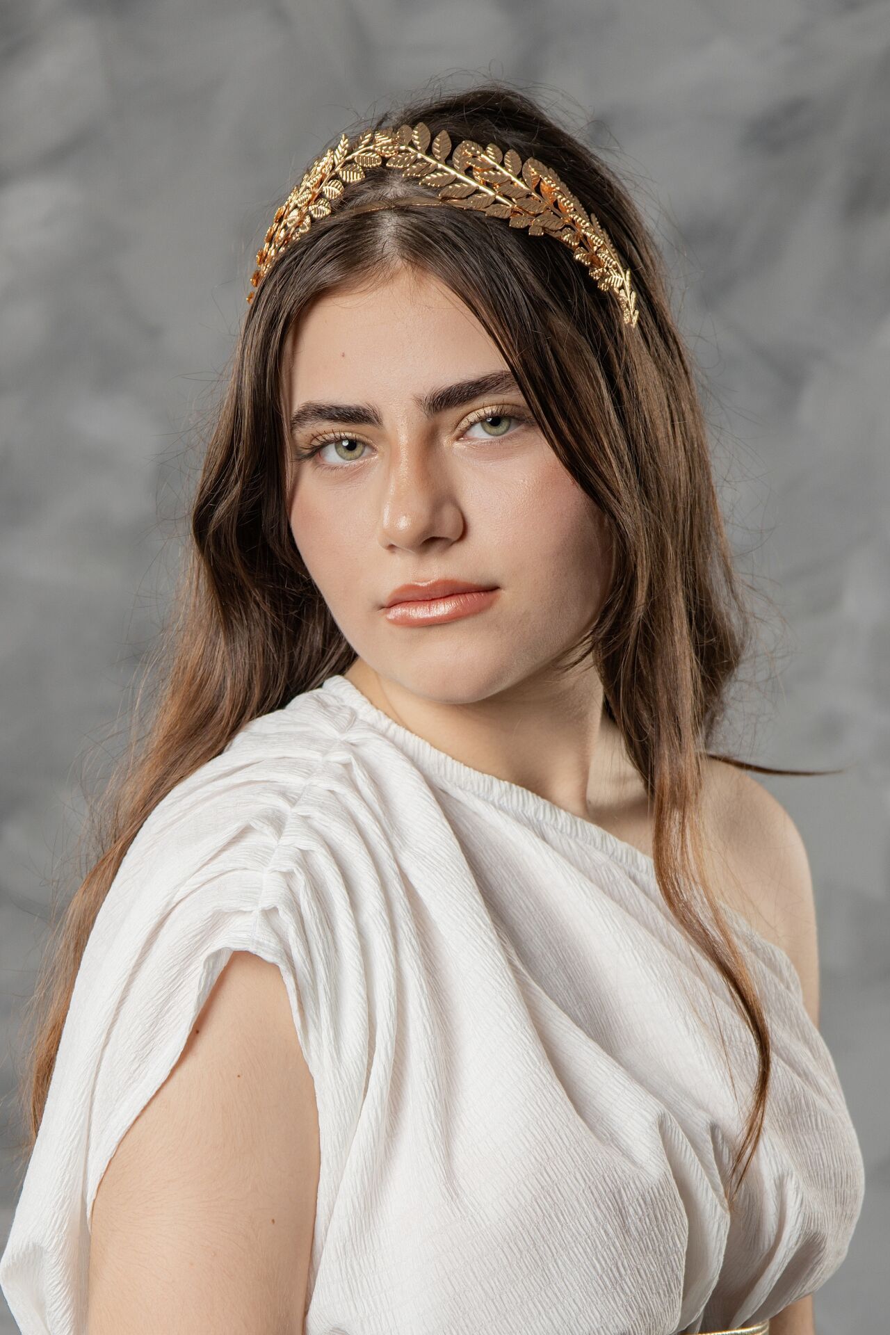 A series of photos showing a model in a white dress wearing a golden leaf crown against a gray background.